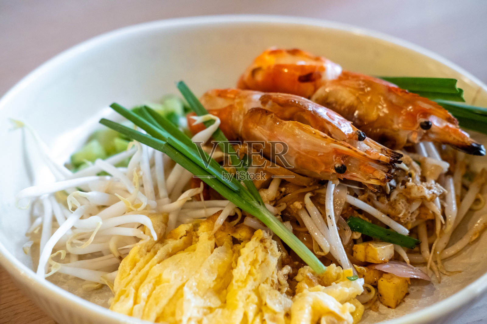 虾仁泰式炒米粉盛在盘子里。这是一道泰国炒米粉菜肴。照片摄影图片