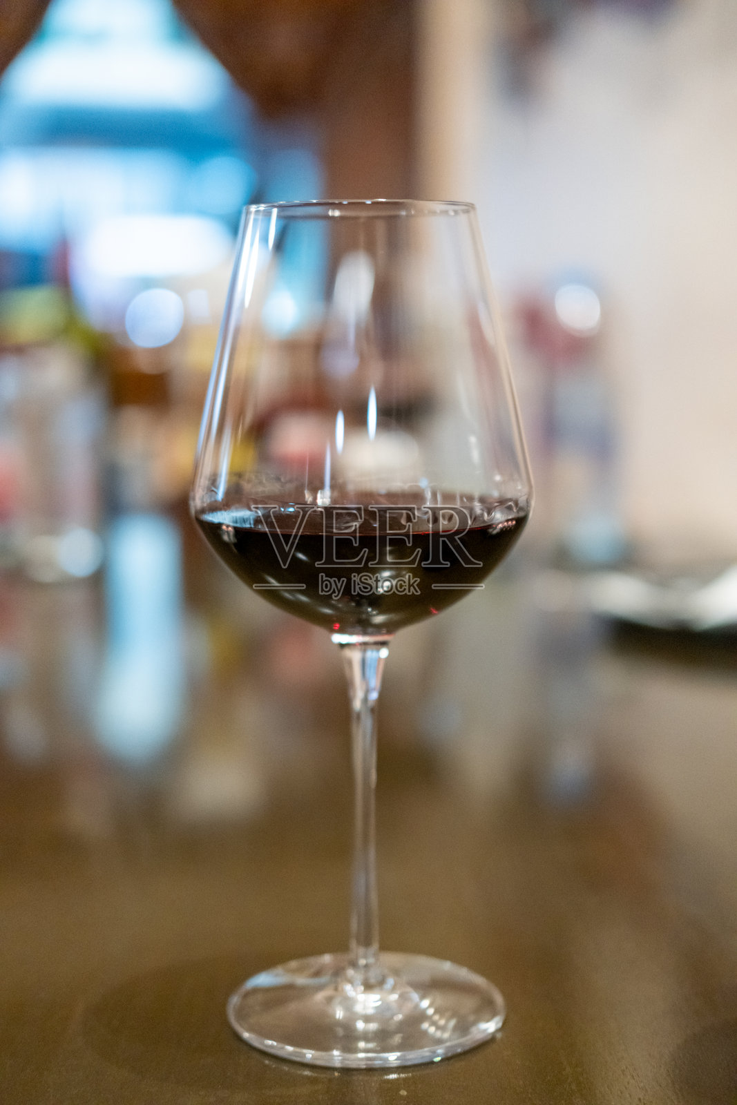 餐桌上的一杯红酒，背景模糊的餐厅环境照片摄影图片