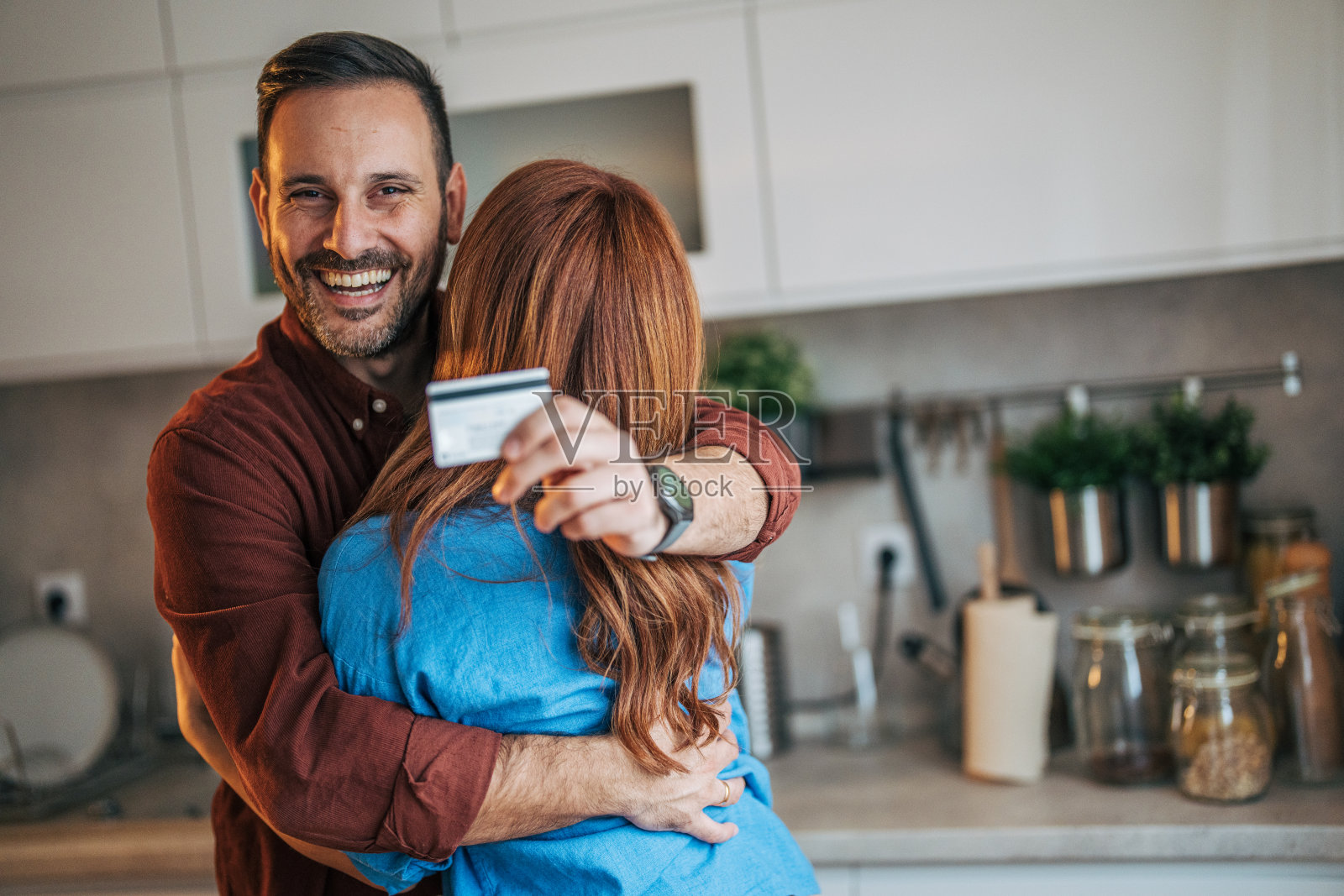 一对快乐的夫妻站在厨房里。照片摄影图片