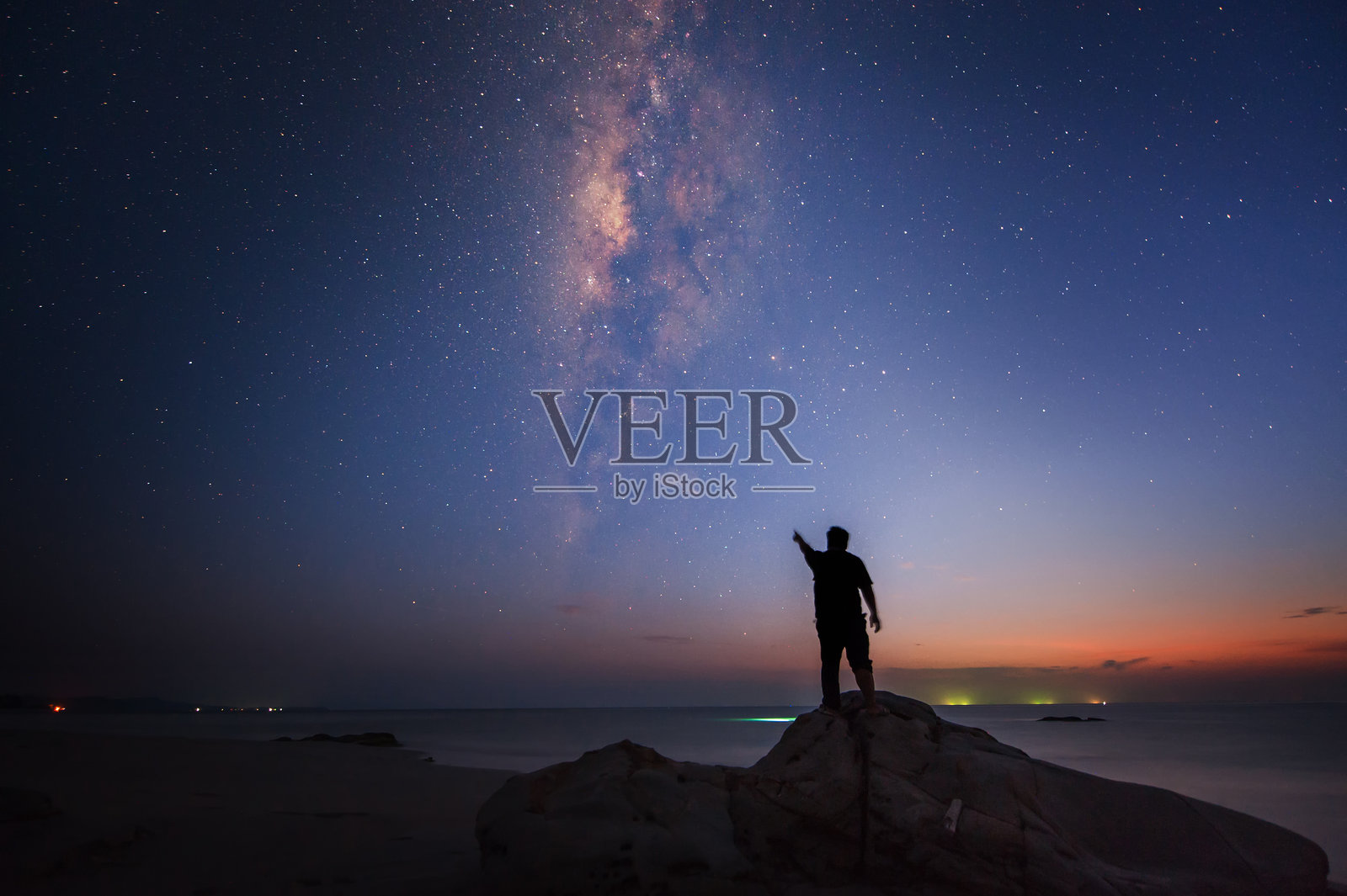 夜晚站立并指向天空的人的剪影照片摄影图片