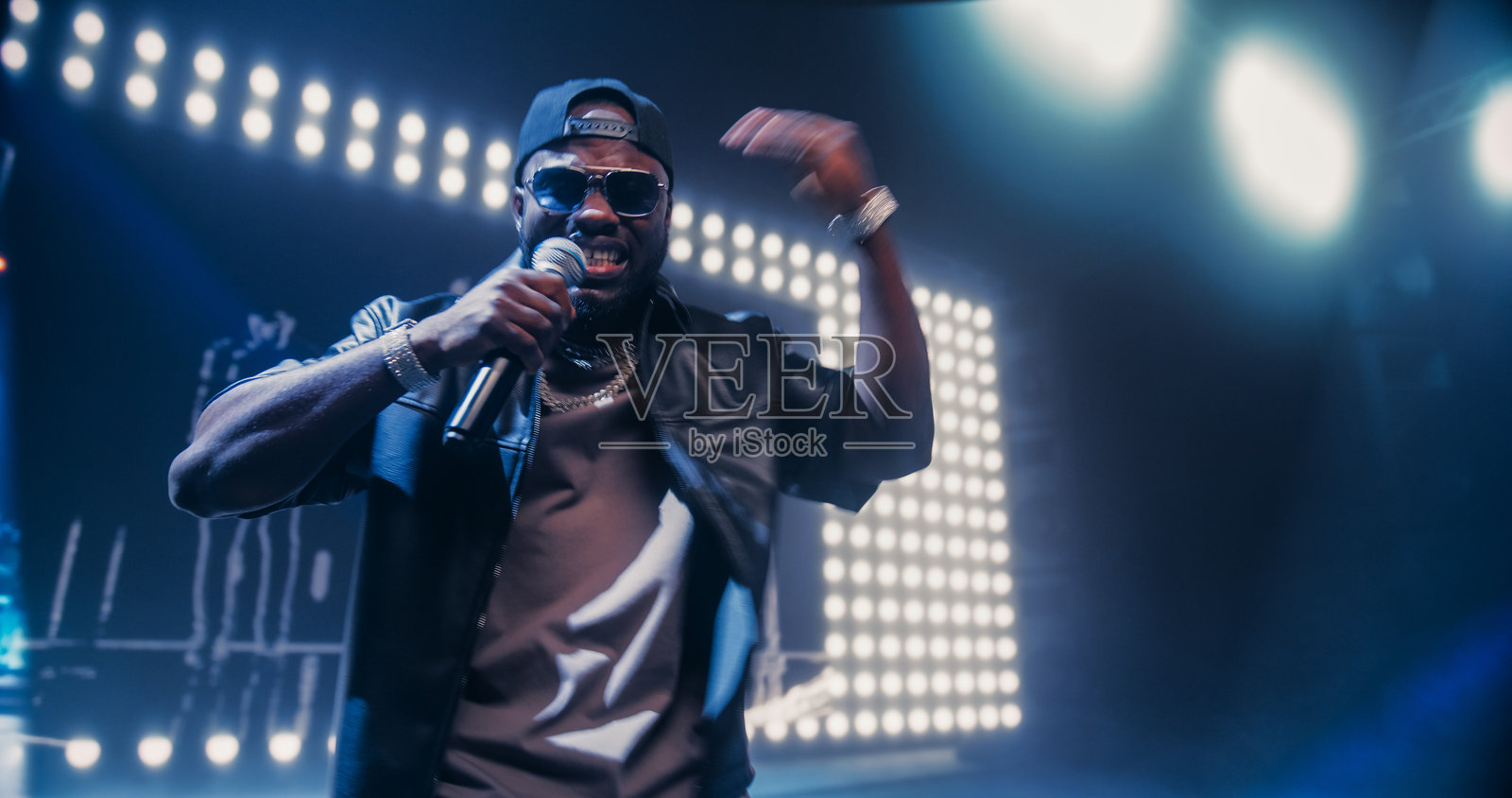 嘻哈音乐会热烈表演：年轻有才华的音乐人在舞台上为兴奋的观众和音乐爱好者演出。女性在非洲艺术家旁边跳舞。照片摄影图片