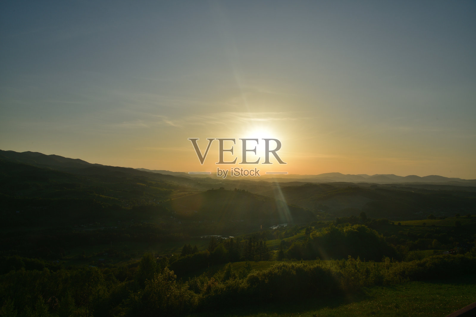 傍晚时分，森林和草地上的全景橙色日落照片摄影图片