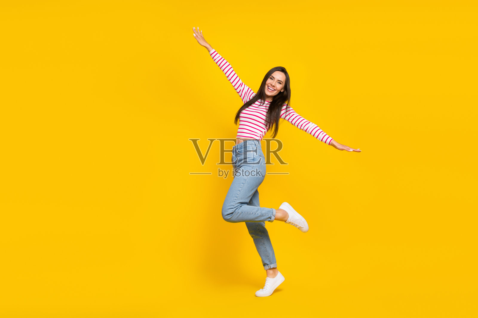 全身照，积极的女游客在夏季旅行中欢欣鼓舞，背景为黄色，空旷无物。照片摄影图片