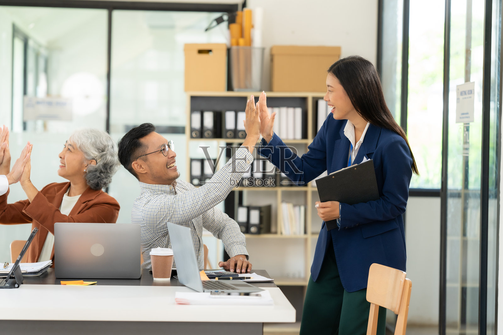 快乐的亚洲商务团队共同庆祝成功的商业合作伙伴关系，创意团队的头脑风暴会议。照片摄影图片