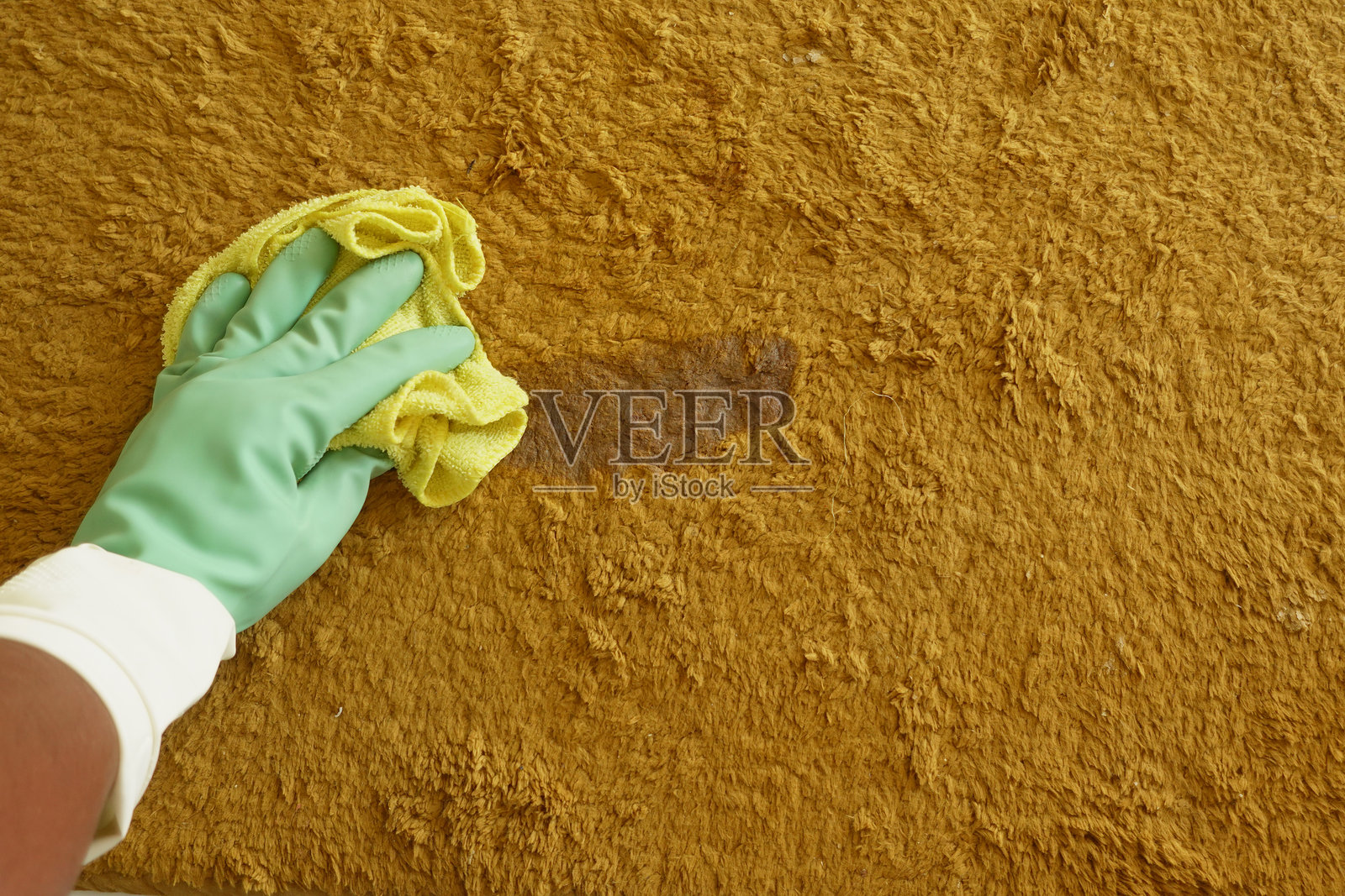 使用黄色布料和保护手套有效清洁污渍墙壁照片摄影图片
