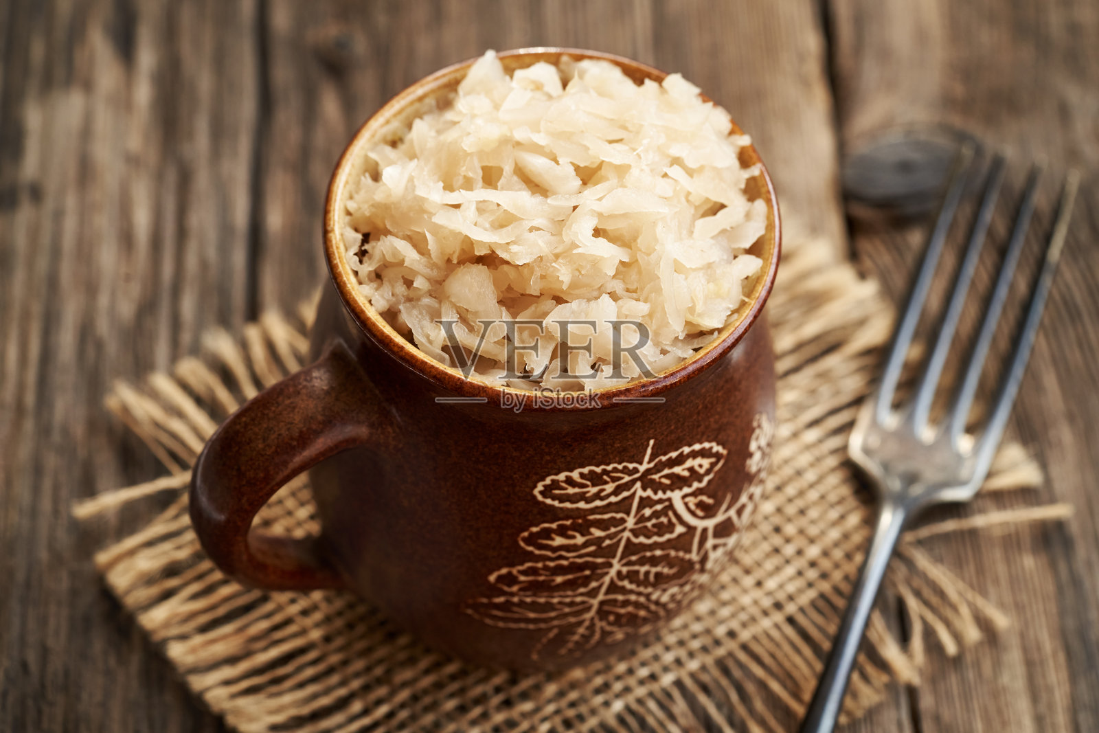 自制发酵卷心菜或酸菜放在木桌上的锅里照片摄影图片