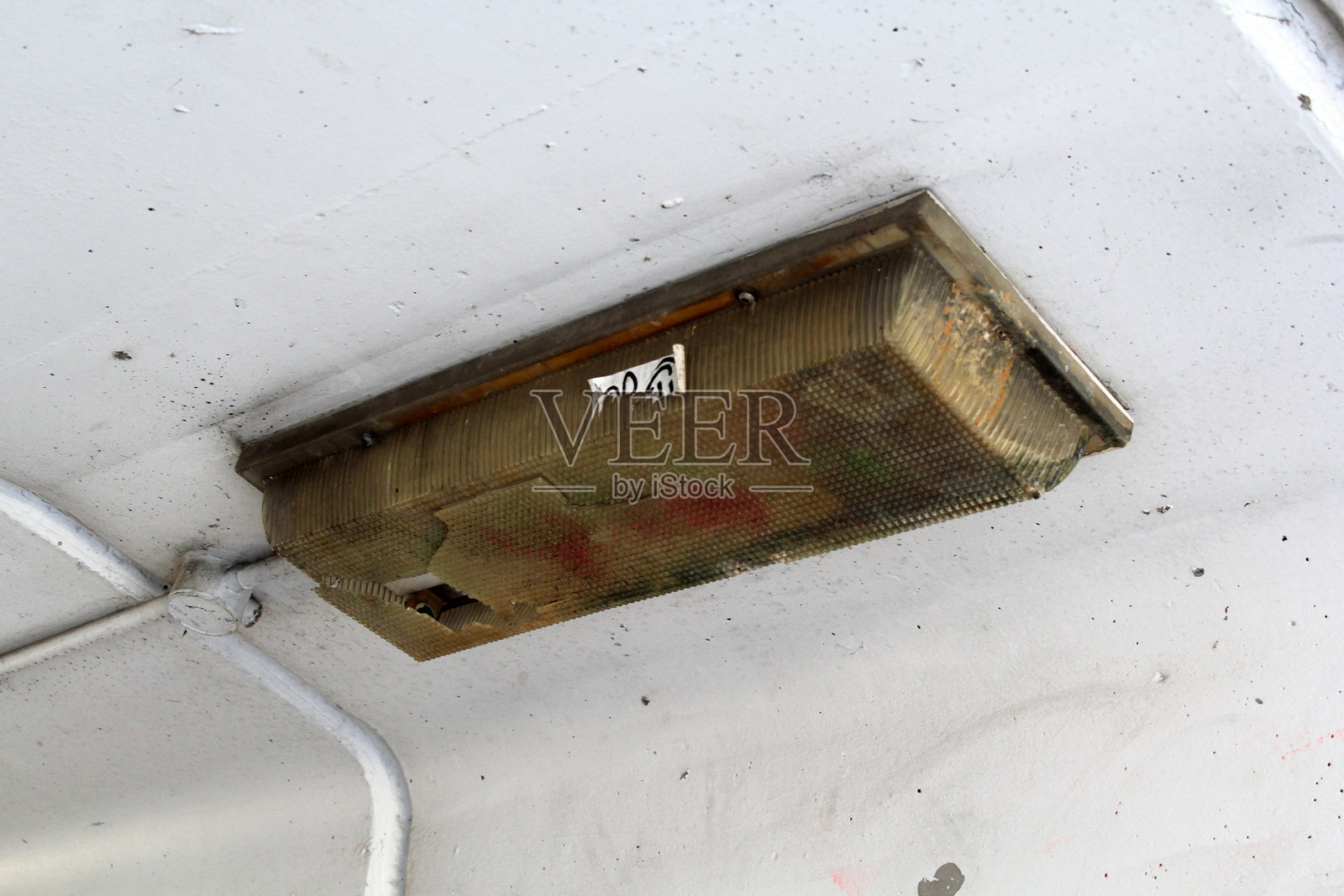 损坏的灯具安装在白色混凝土天花板上照片摄影图片