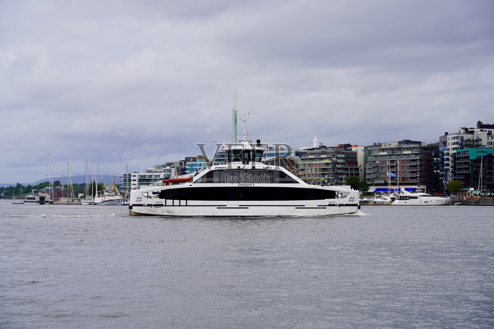 乘客船奥斯陆峡湾号在多云的天空下穿行于奥斯陆港口照片摄影图片