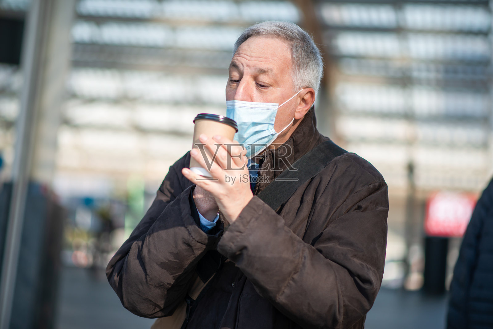 戴着防护口罩的商人在户外喝咖啡照片摄影图片
