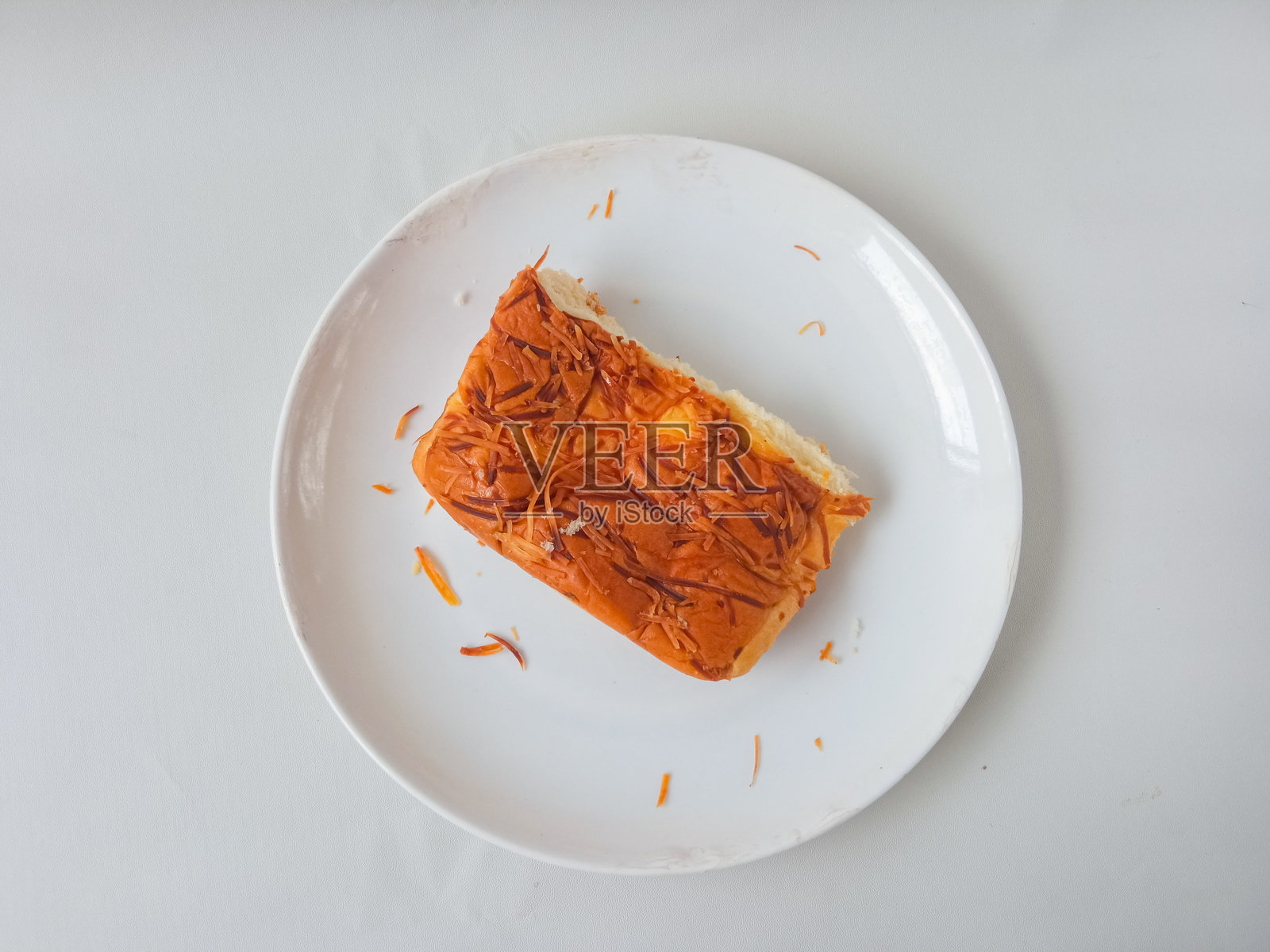 白色背景上盘子里放着用小麦面粉制作的食物或面包，上面有奶酪配料。照片摄影图片