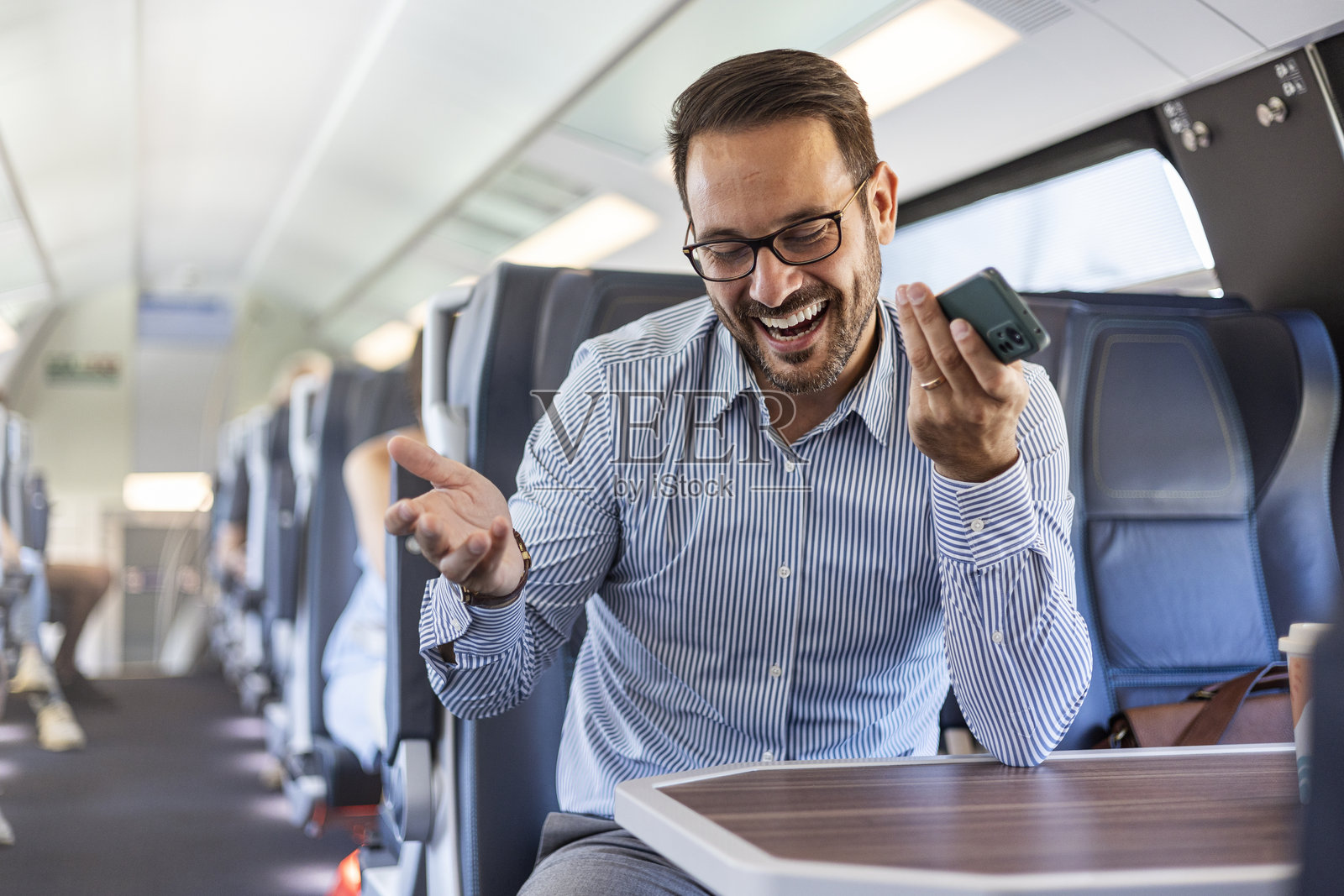 商人在火车旅行中打电话时大笑照片摄影图片