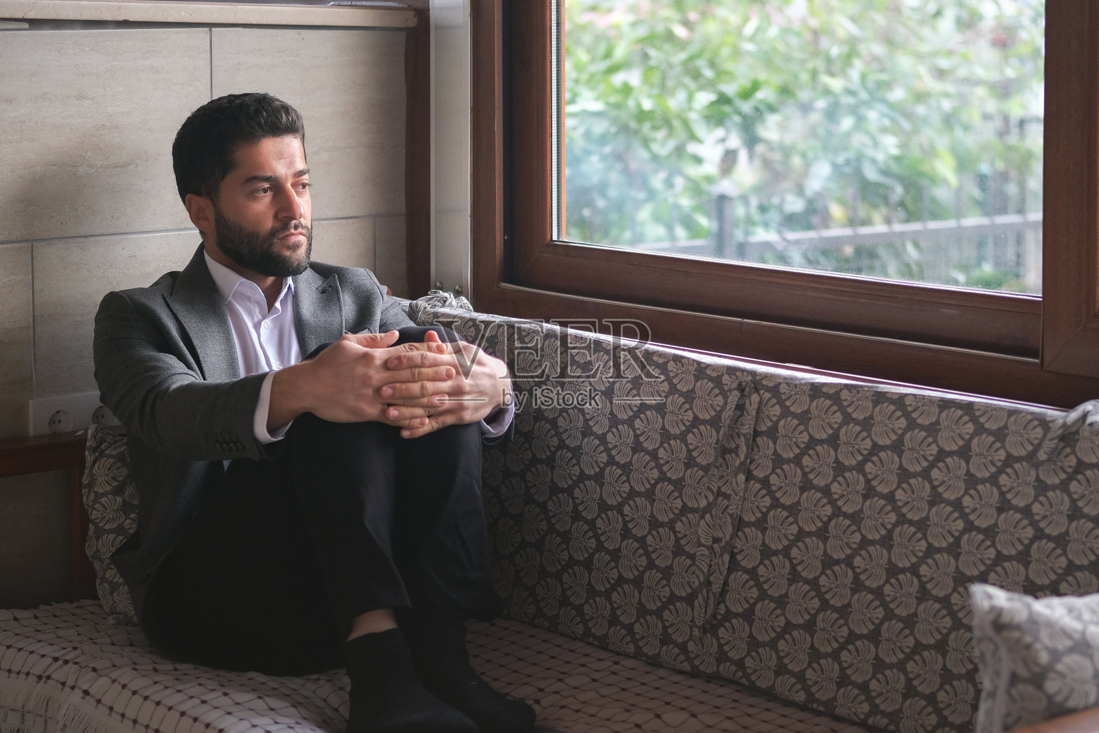 深思熟虑的商人坐在沙发上。照片摄影图片