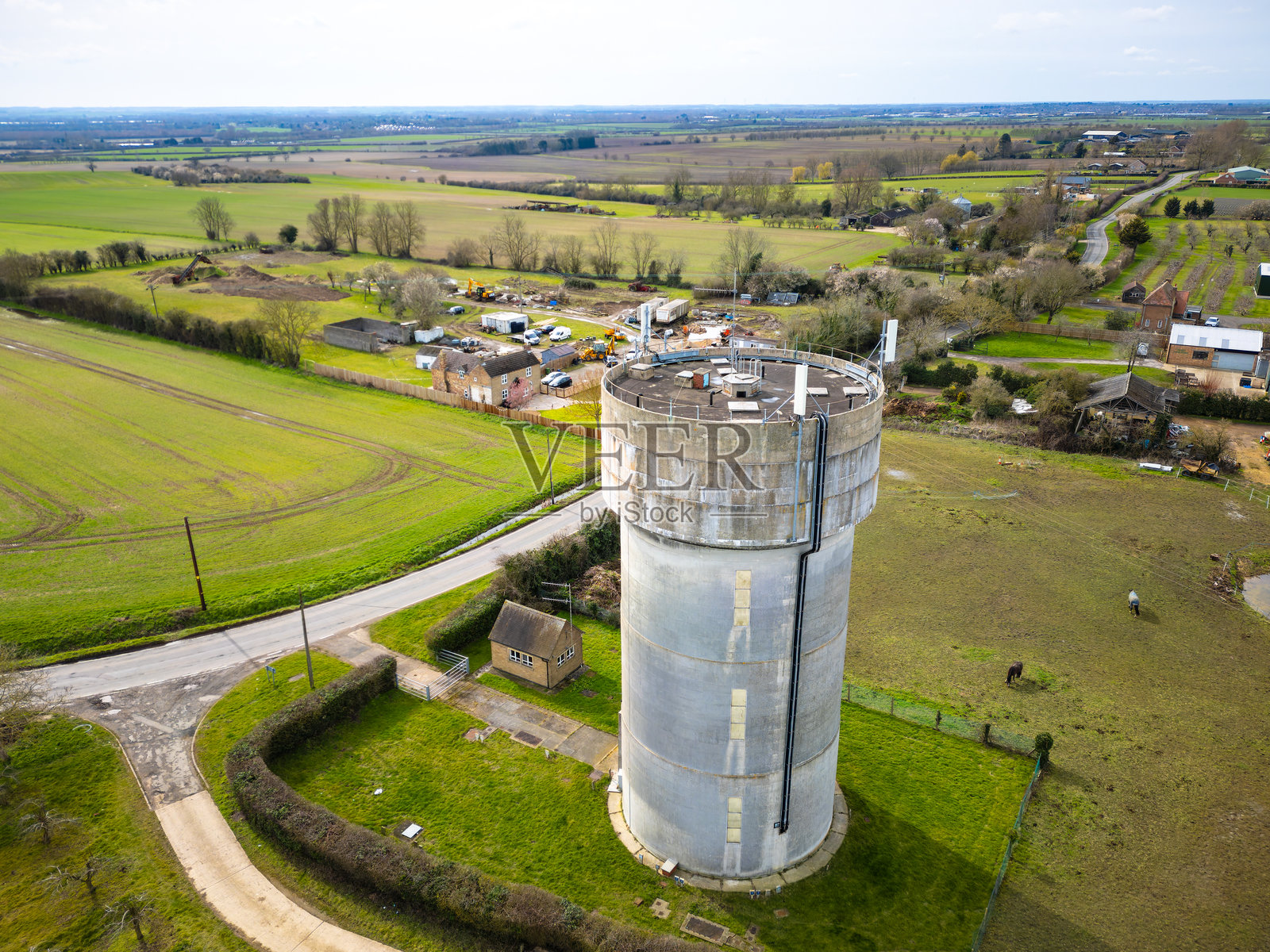 无人机视角下，英格兰一个大村庄尽头的巨大混凝土水塔。照片摄影图片