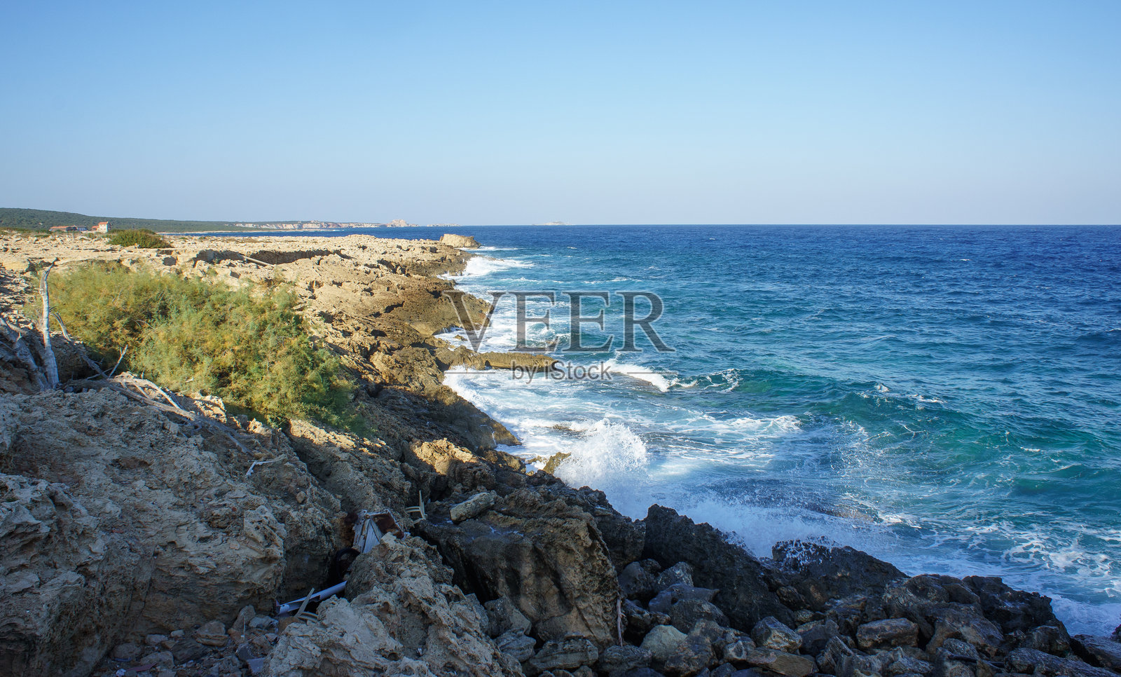 阳光明媚的日子里，海浪拍打着崎岖的悬崖，沿着美丽的海岸线。照片摄影图片