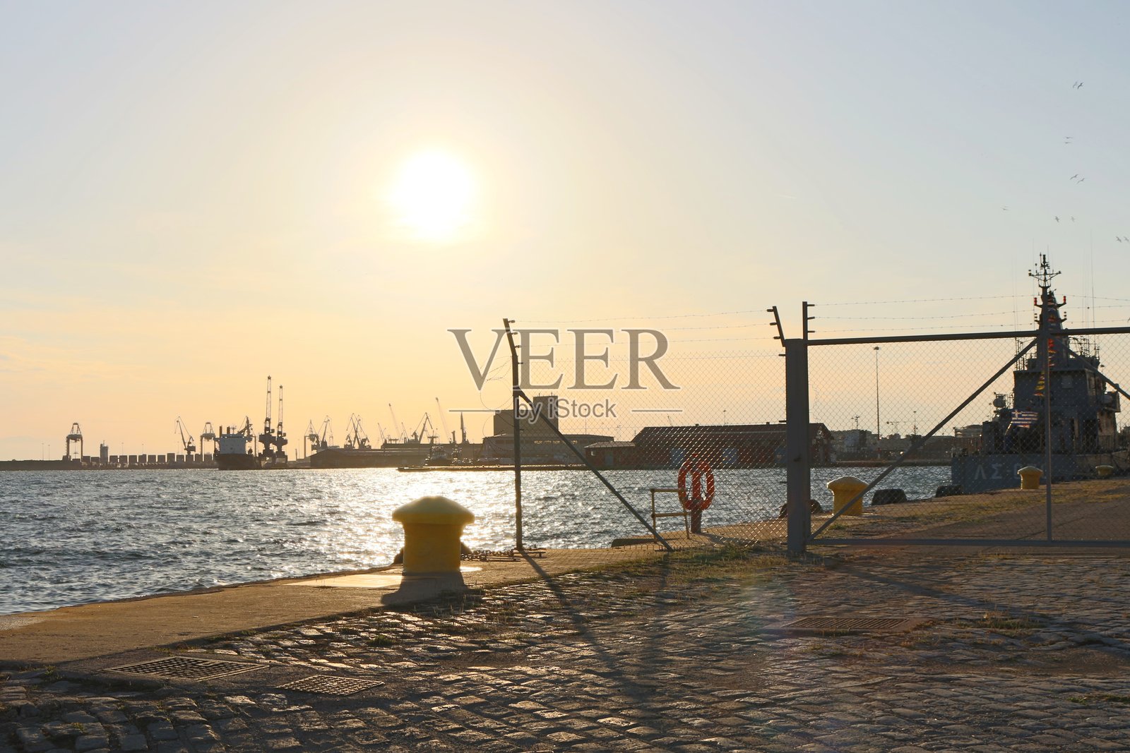 日落剪影：塞萨洛尼基港口的货箱照片摄影图片