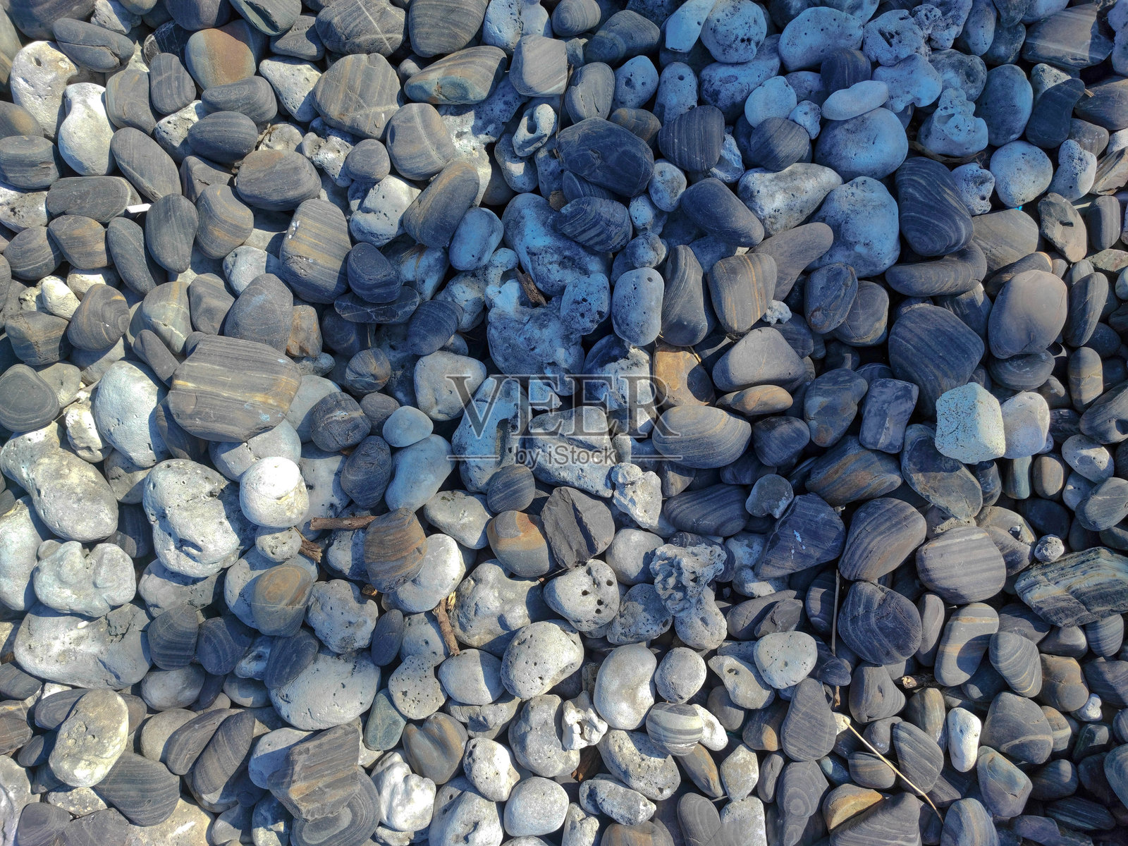 黑色与金色条纹的河石背景。照片摄影图片