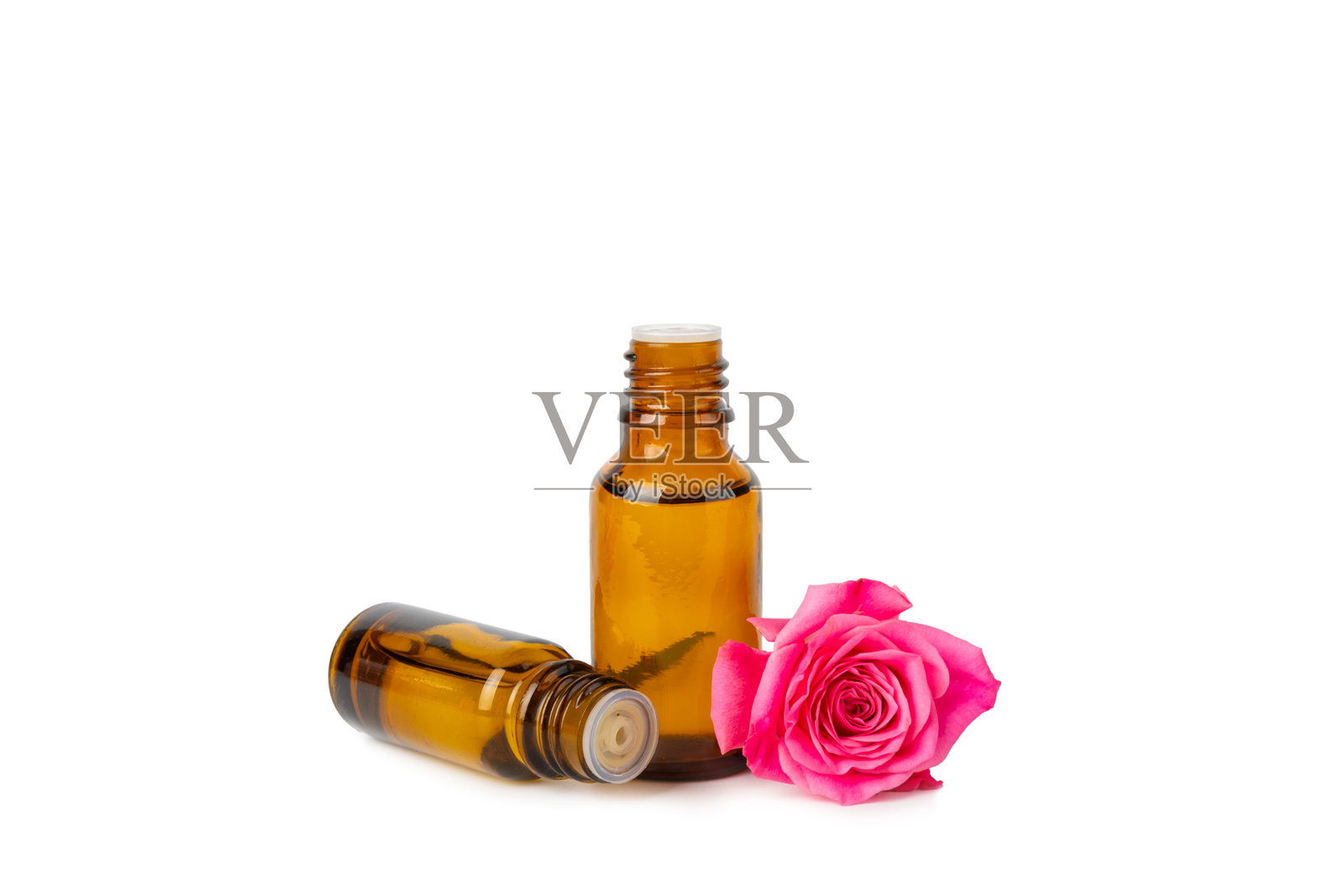 白色背景上的玫瑰精油。玫瑰和一瓶玫瑰香水。芳香疗法治疗。美容概念。水疗程序。天然有机油。抗压和排毒放松。照片摄影图片