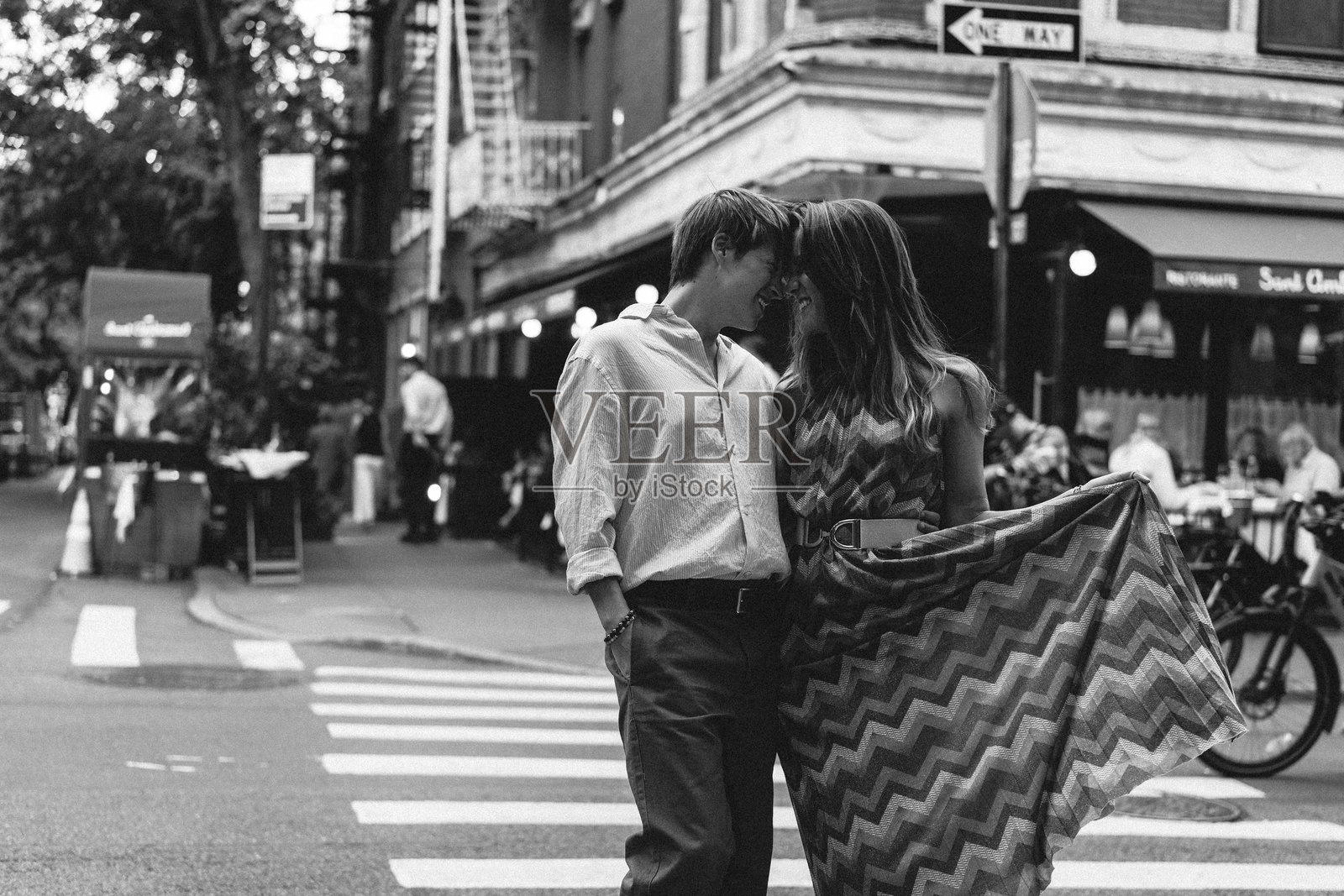 一对浪漫的情侣在美丽的城市绿地中相拥，周围环绕着自然景观照片摄影图片