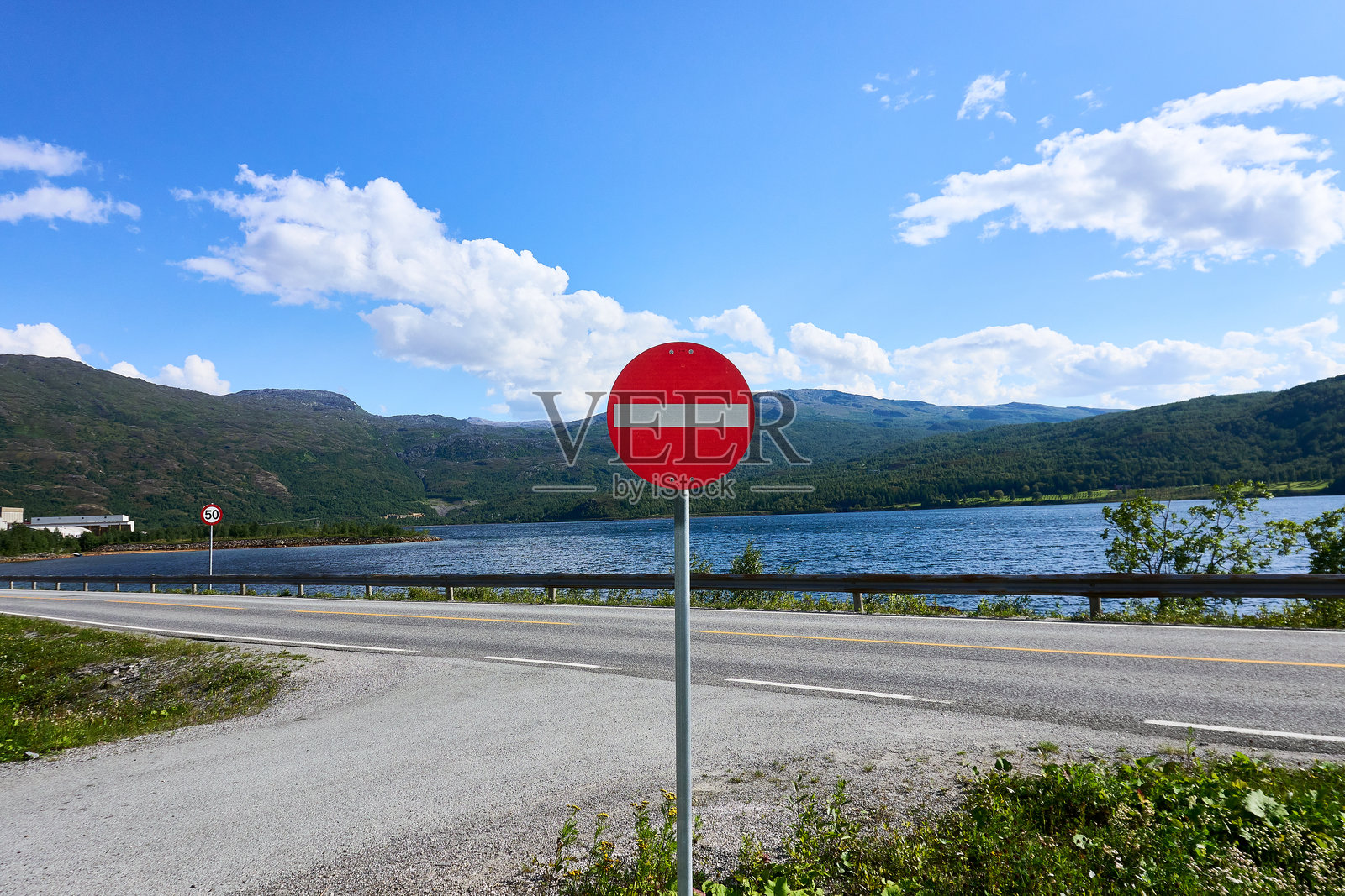 高速公路附近的禁止入内标志，背景是山脉和湖泊照片摄影图片