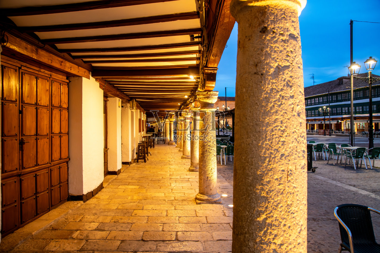 夜晚的普拉扎·马约广场拱廊，木质天花板和石铺地面被灯光照亮照片摄影图片