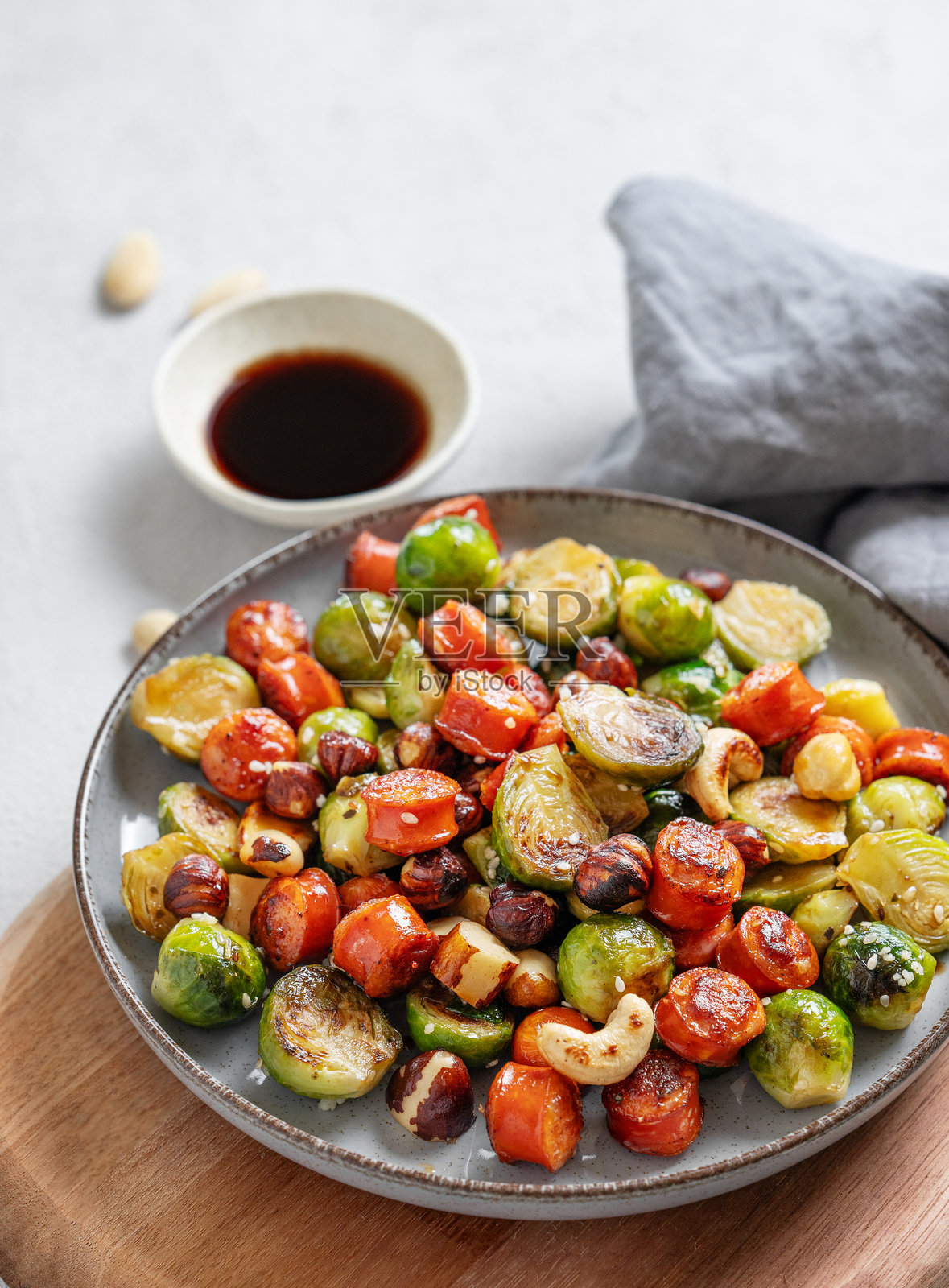 布鲁塞尔芽菜配西班牙香肠、坚果和芝麻，浸泡在酱油中。照片摄影图片