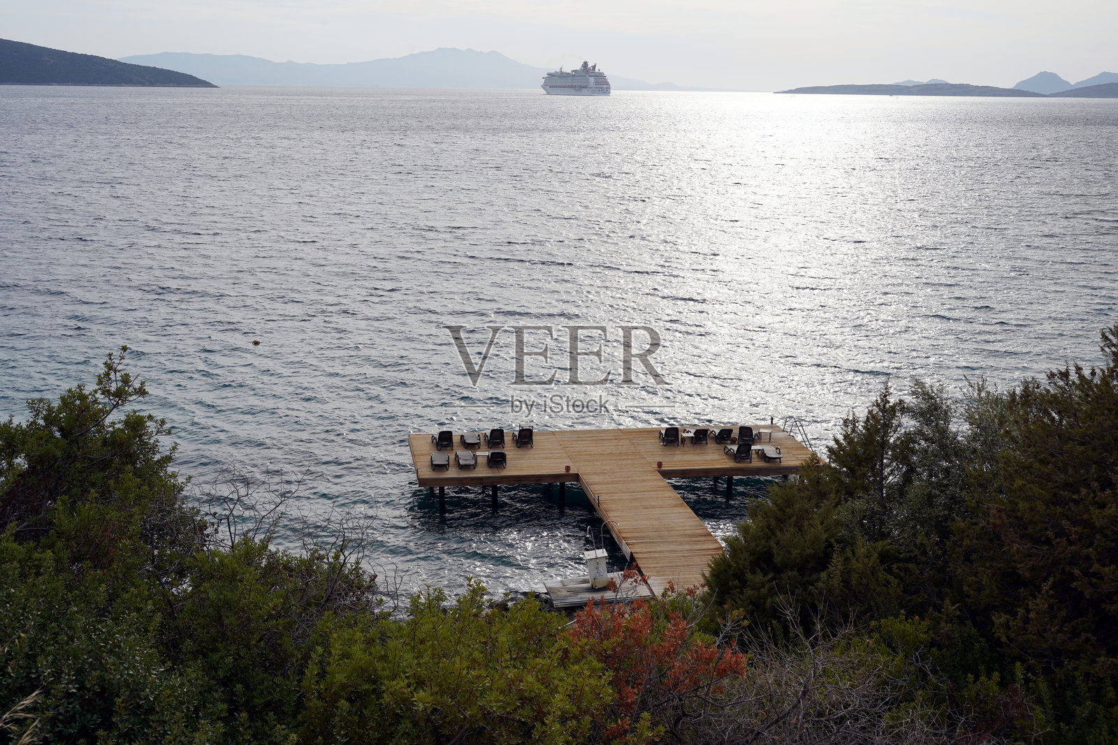 陡坡底部的海边木质游泳平台。照片摄影图片