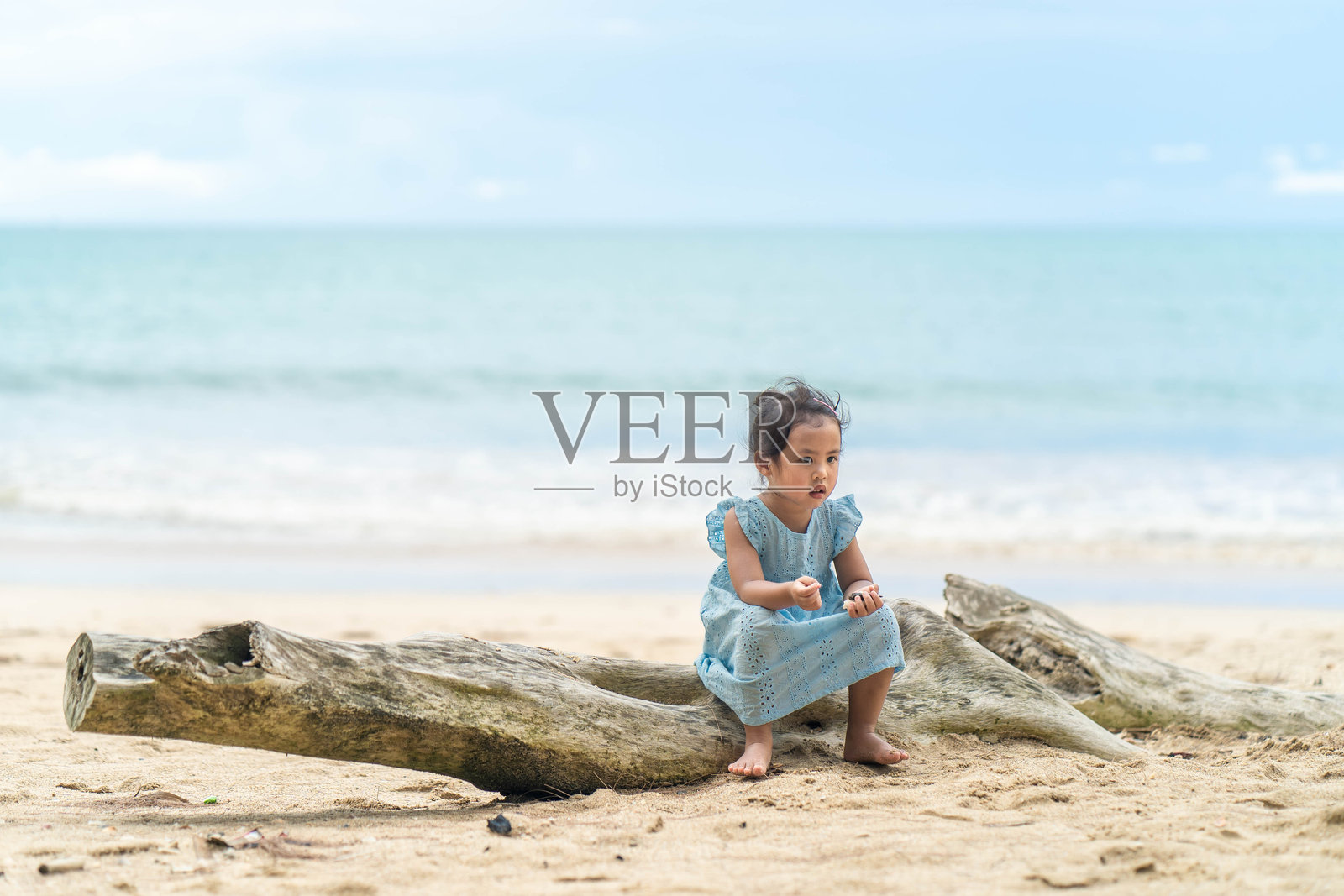 女孩坐在海滩上照片摄影图片