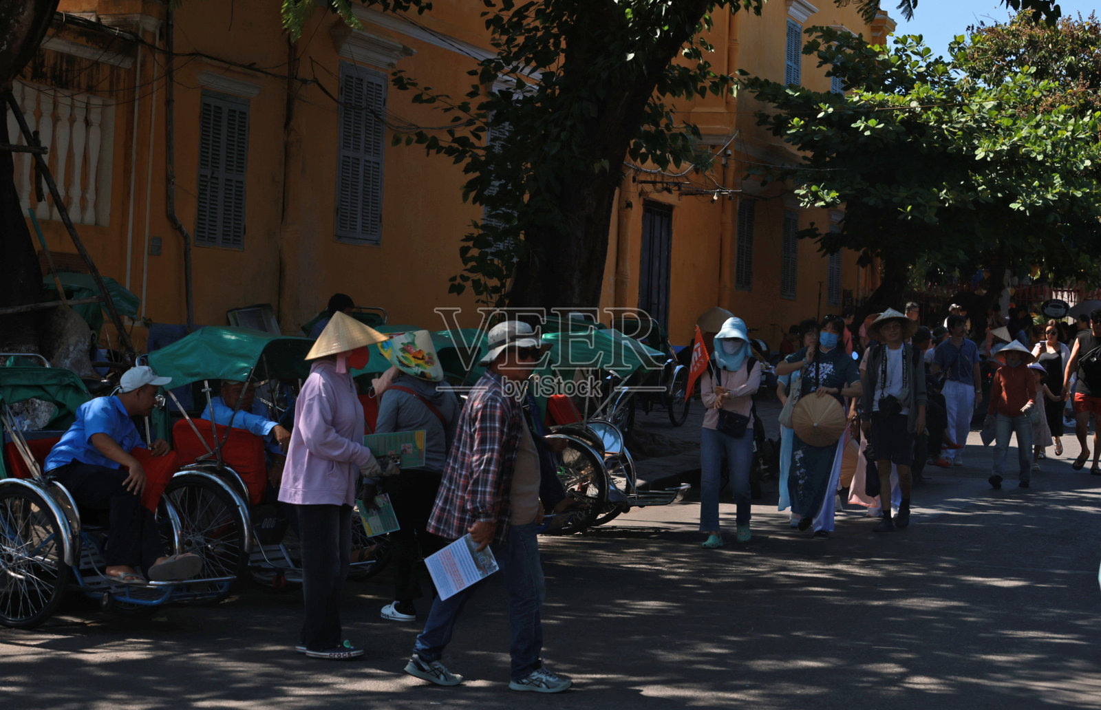 在会安的街道上，一名身份不明的人力车骑手在等待游客。照片摄影图片