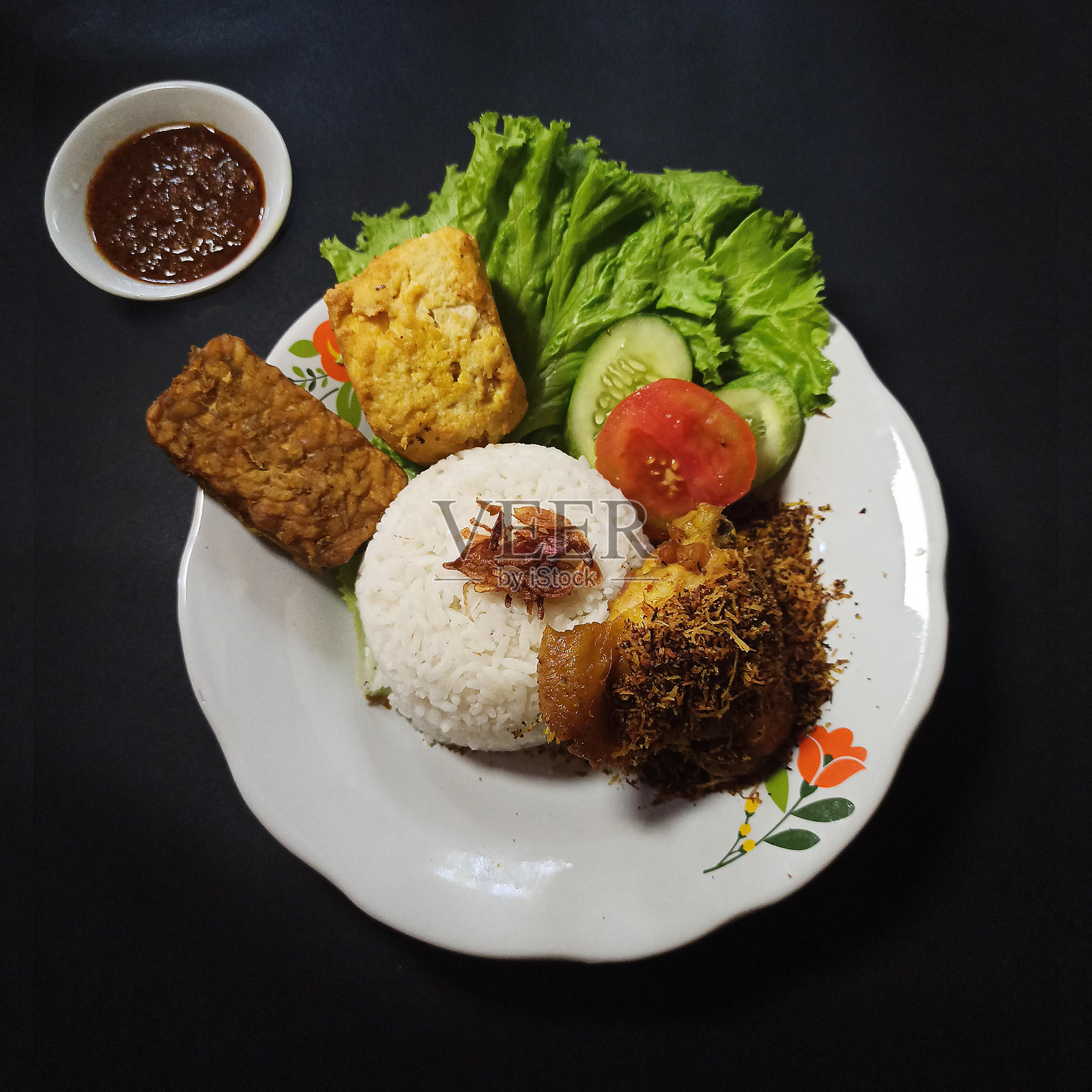 印尼风味炸鸡克雷梅斯配香脆的沙爹酱、天贝、豆腐和蔬菜。照片摄影图片