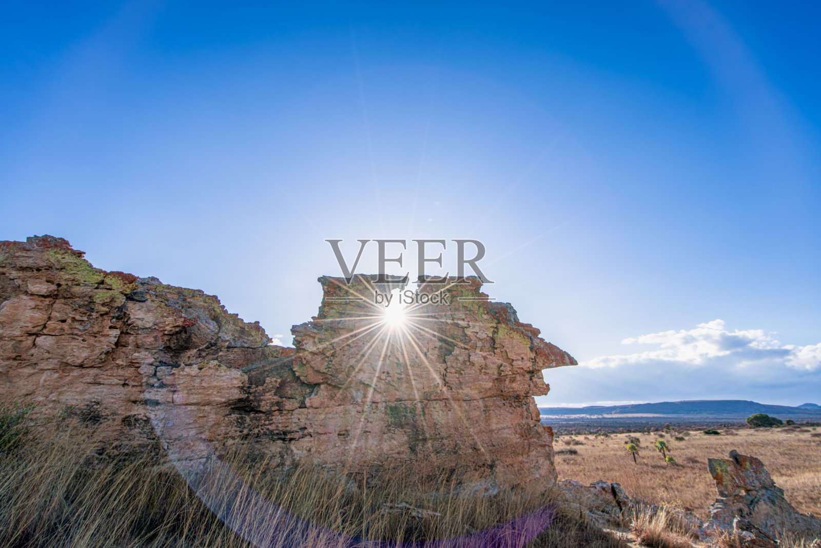 马达加斯加伊萨洛国家公园自然岩石窗户透出的日落。照片摄影图片