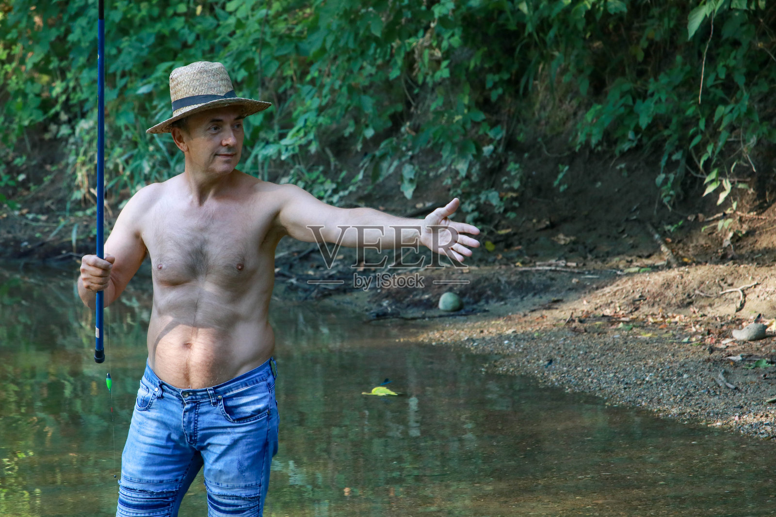 在清澈的河流中放松的银发老人在钓鱼照片摄影图片