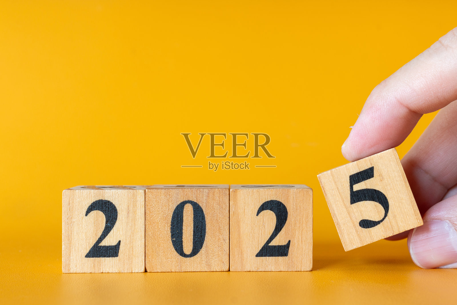 在明亮的黄色背景上，黑色数字排列成2025的木块。照片摄影图片