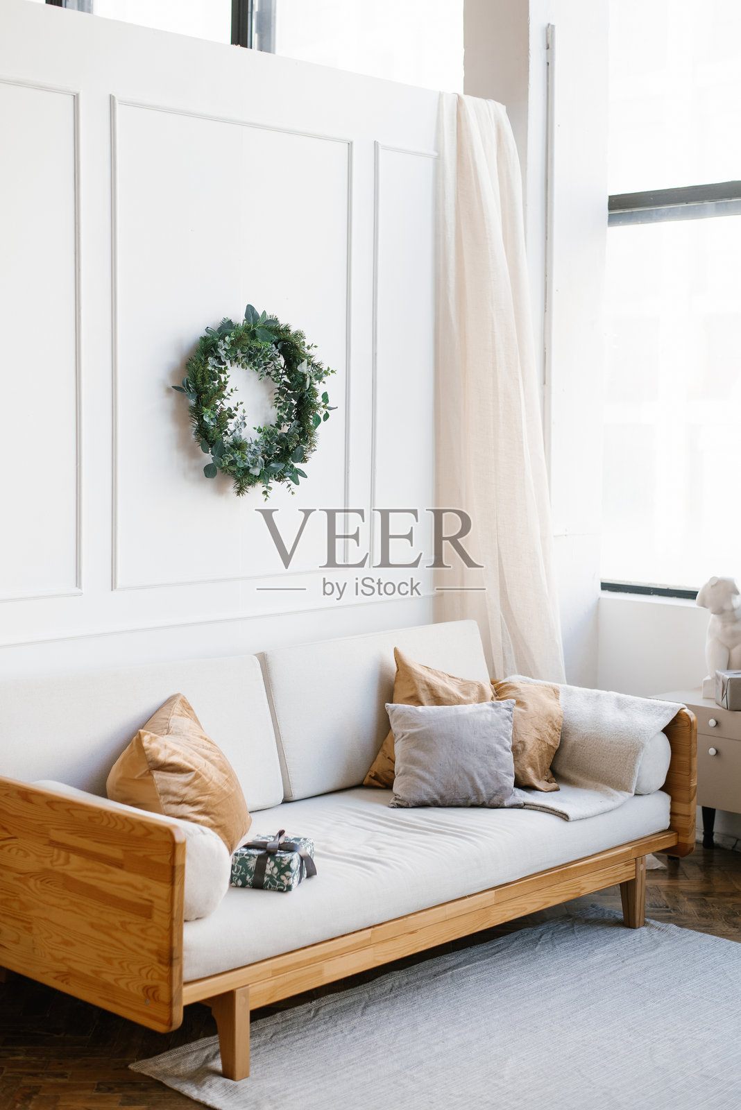 明亮的沙发和靠垫装饰在客厅中，采用斯堪的纳维亚风格，庆祝圣诞节和新年。照片摄影图片