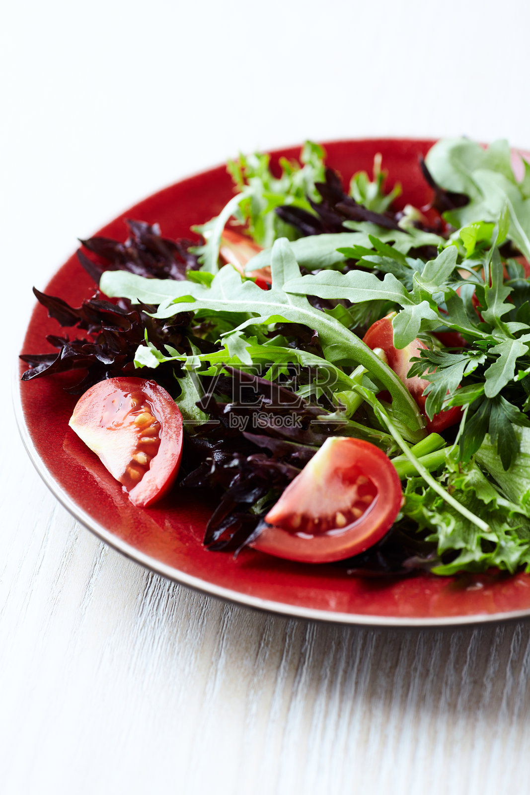 新鲜番茄和芝麻菜沙拉，背景为明亮的石材。特写。留白空间。照片摄影图片