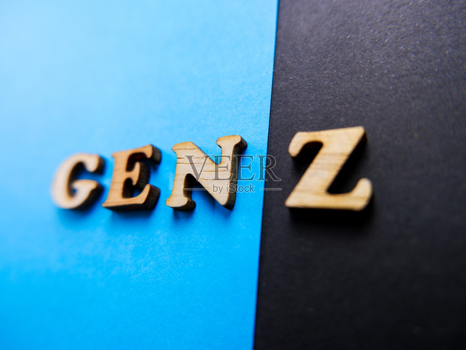 “GEN Z”字样的木制字母概念，背景为蓝色和黑色。照片摄影图片