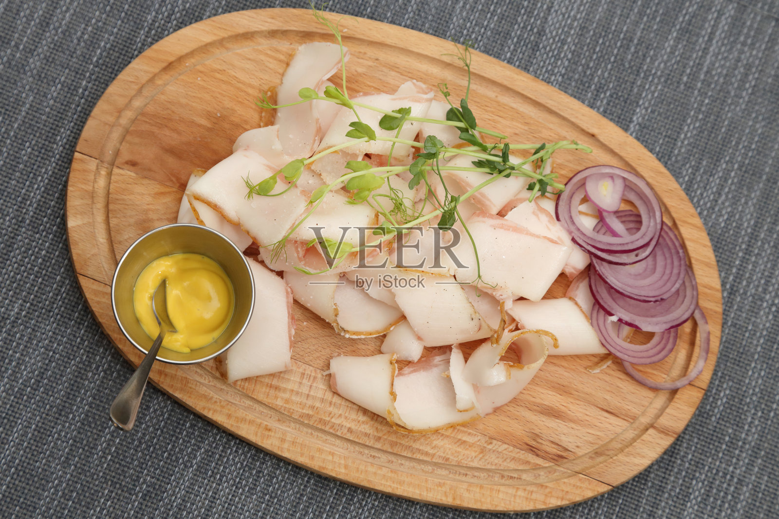 薄切的猪油片配洋葱和芥末。木板上的猪油、洋葱和芥末。照片摄影图片
