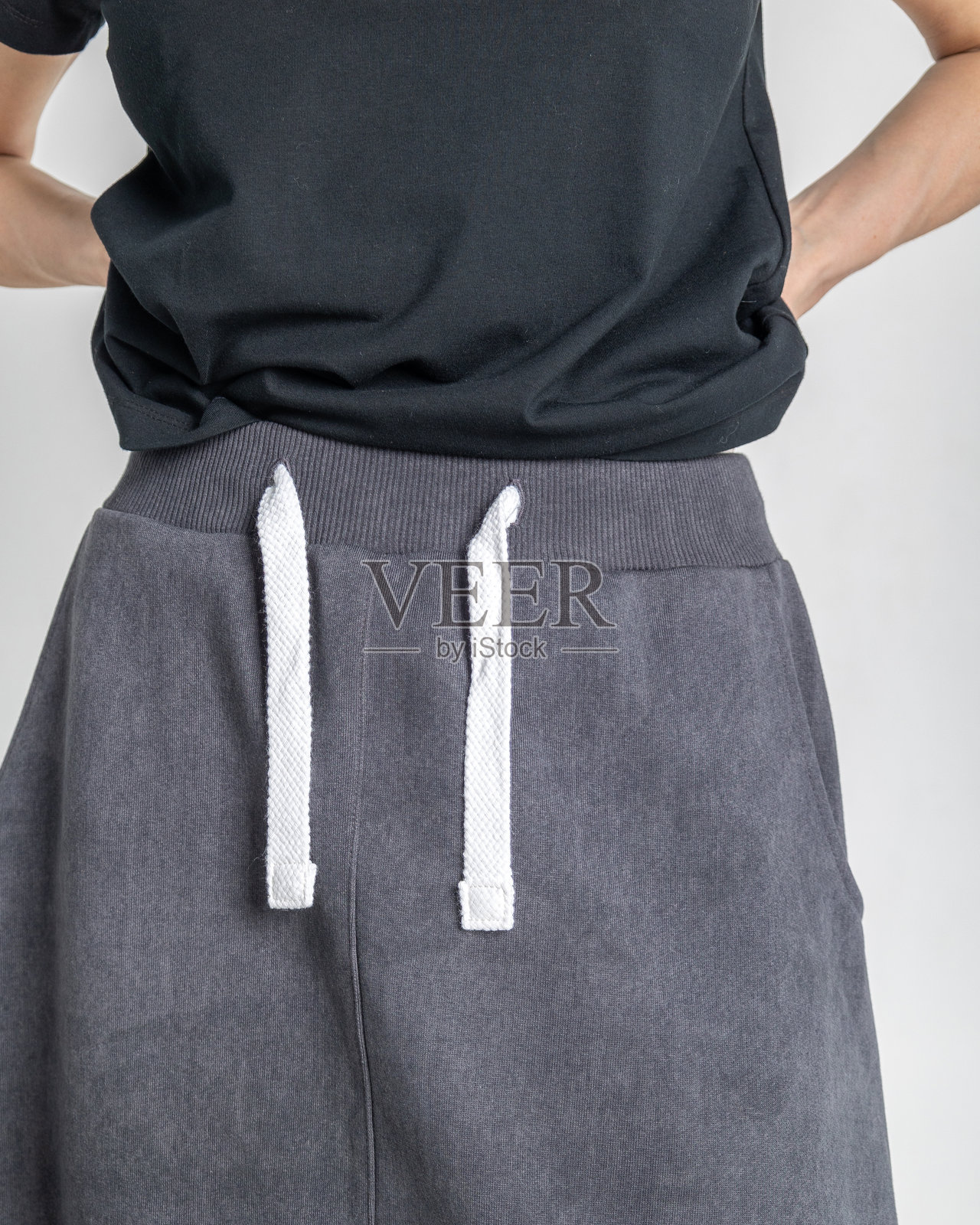 浅色背景下女性身穿黑色衣物的特写照片。垂直构图。照片摄影图片