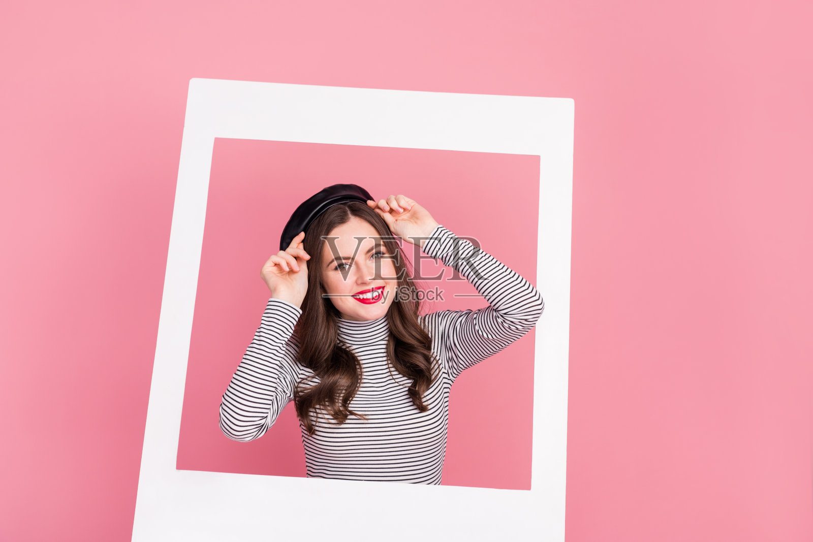 时尚迷人的女士在柔和色彩的背景下试戴新帽子，拍照框架，展示精品店促销。照片摄影图片