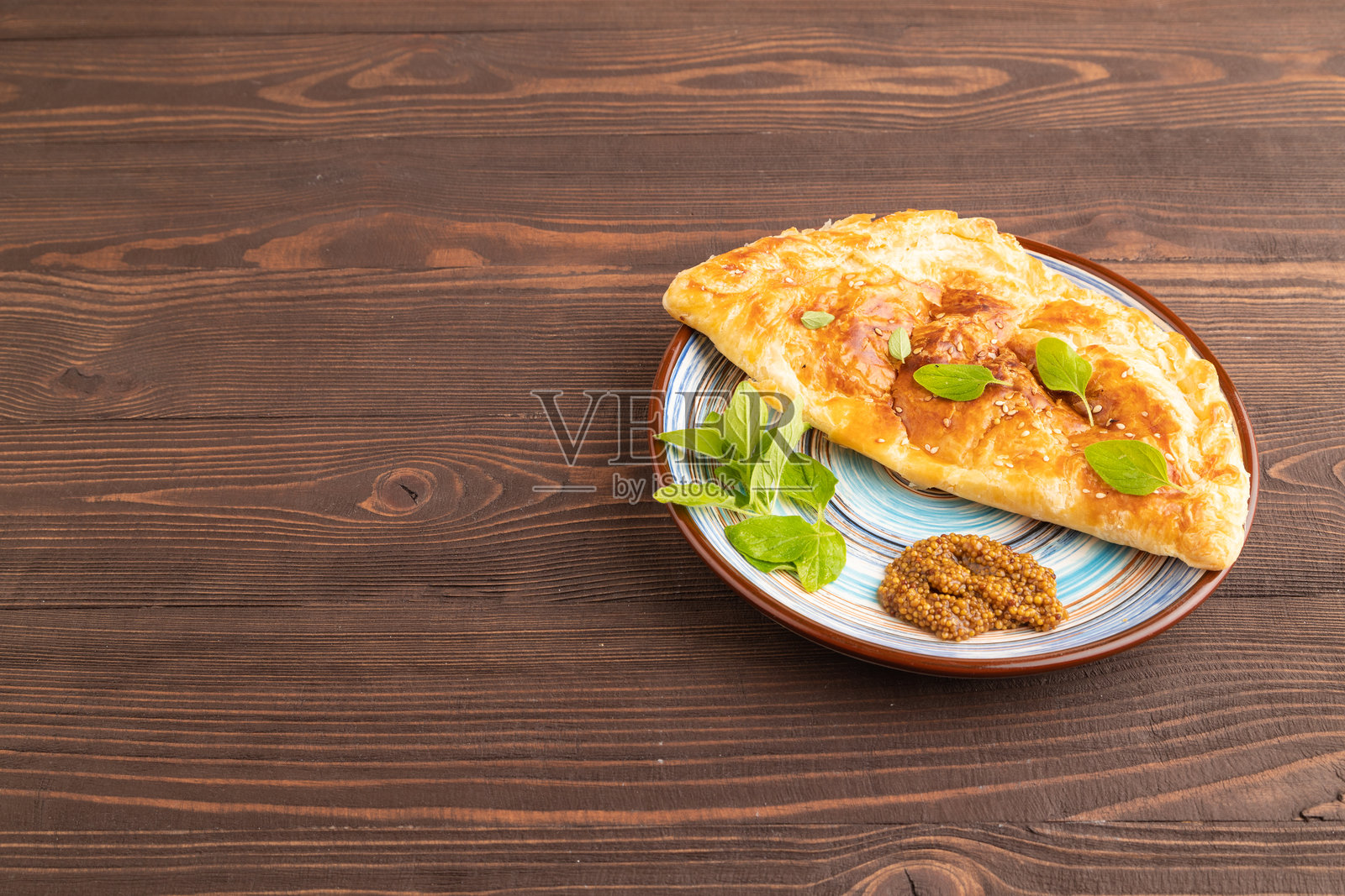 自制的奶酪和肉馅煎饼，炸至金黄，放在棕色木板上。侧面视图，留白空间。照片摄影图片