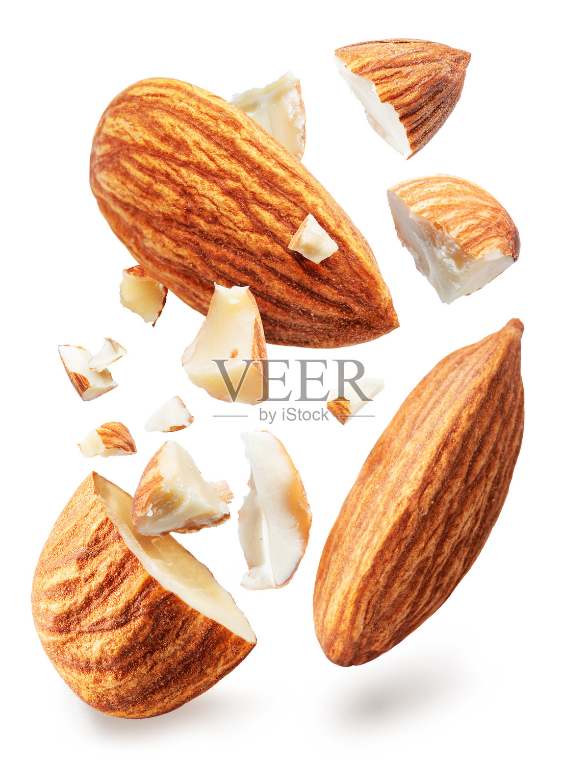 杏仁坚果一分为二，杏仁坚果的碎片悬浮在空中，背景为白色。文件包含抠图路径。照片摄影图片