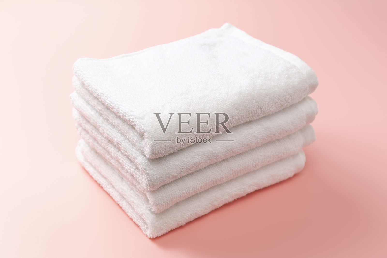 粉色背景上的白色毛巾照片摄影图片