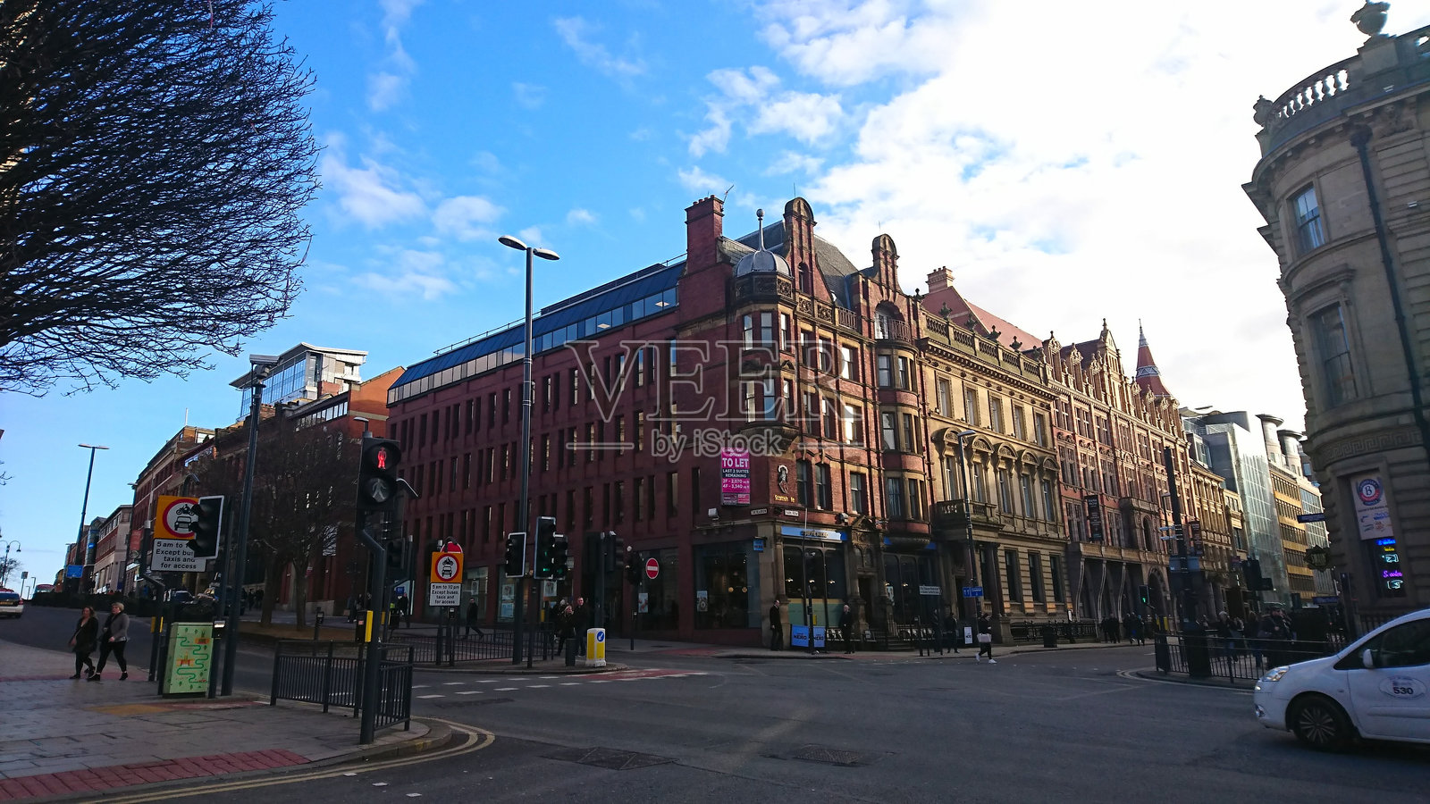 一个普通的交叉口，行人穿行，汽车在历史建筑旁行驶照片摄影图片