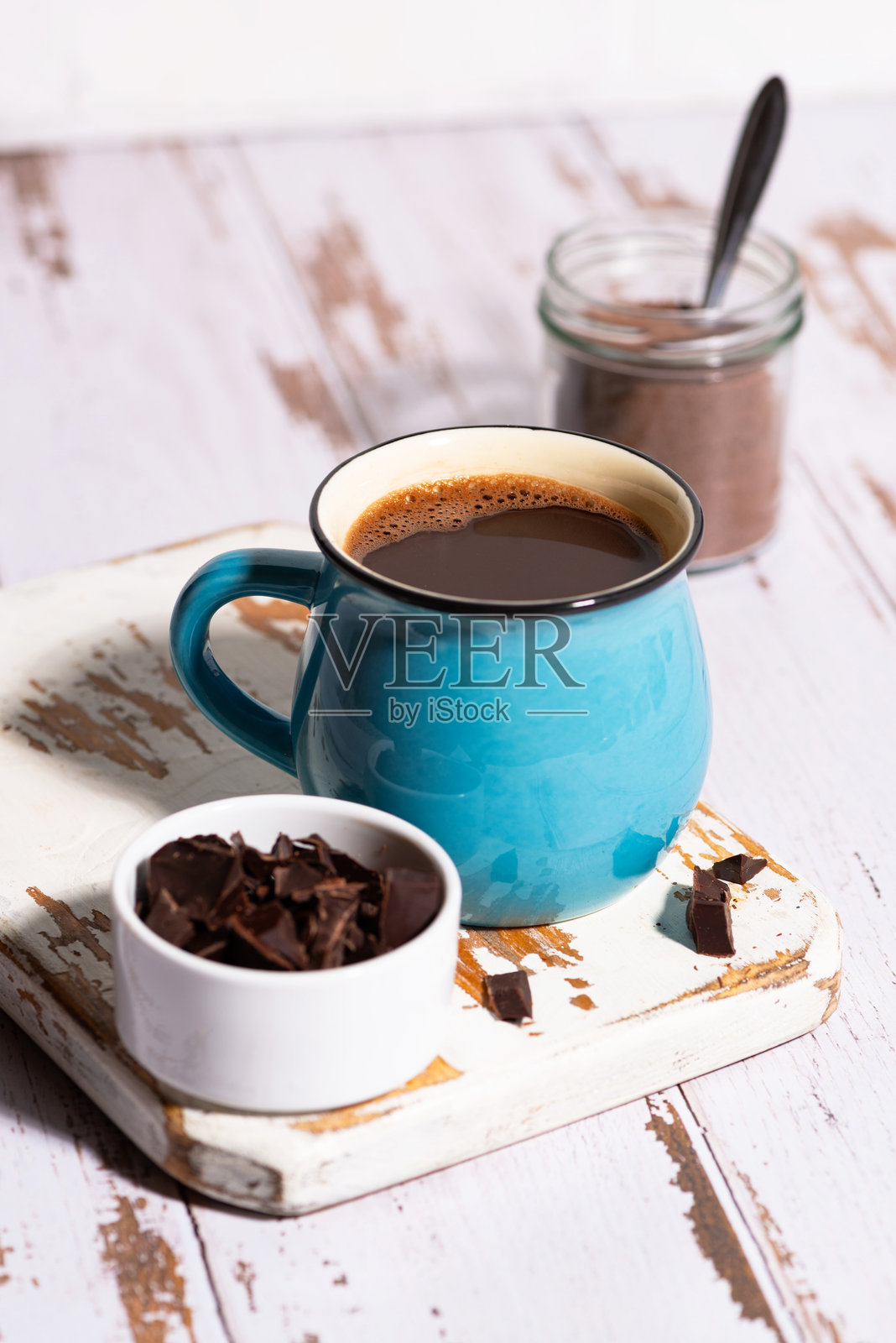 白色桌子上的蓝色热巧克力杯，垂直特写照片摄影图片