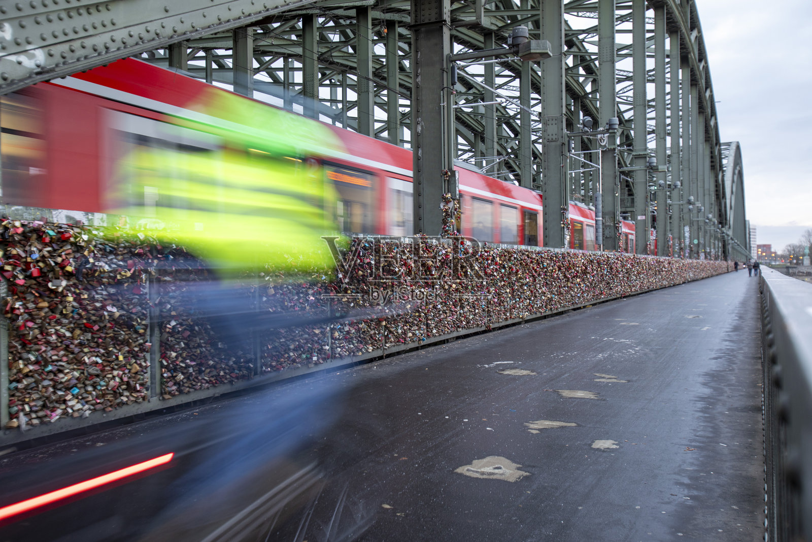 霍亨索伦桥上的骑自行车者和运动模糊的火车照片摄影图片
