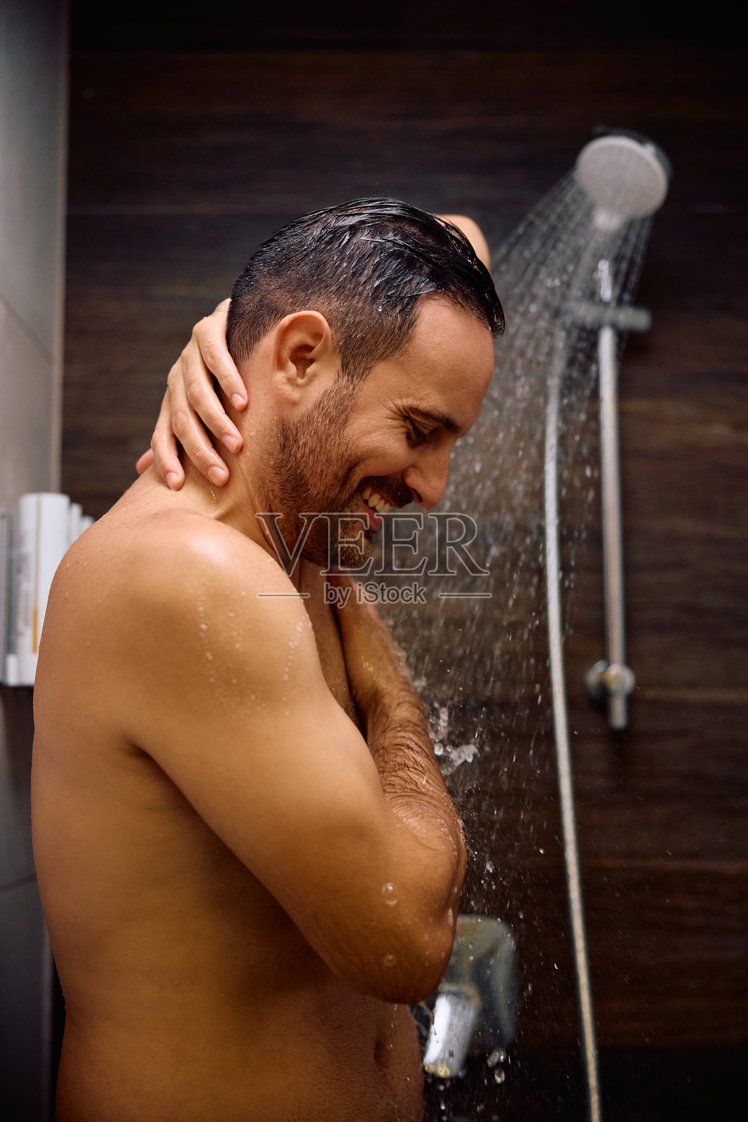 快乐的男人在浴室里享受淋浴。照片摄影图片