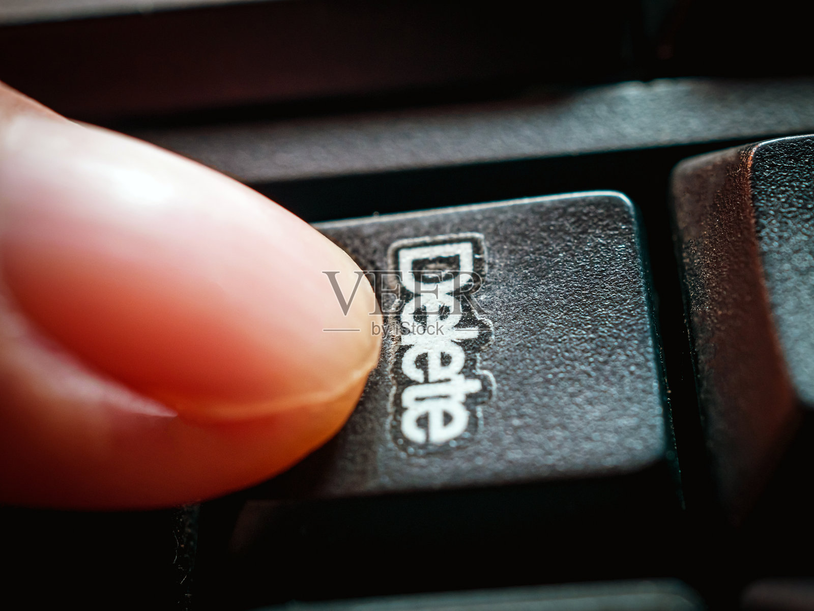 特写镜头，手指按下键盘上的删除键。照片摄影图片