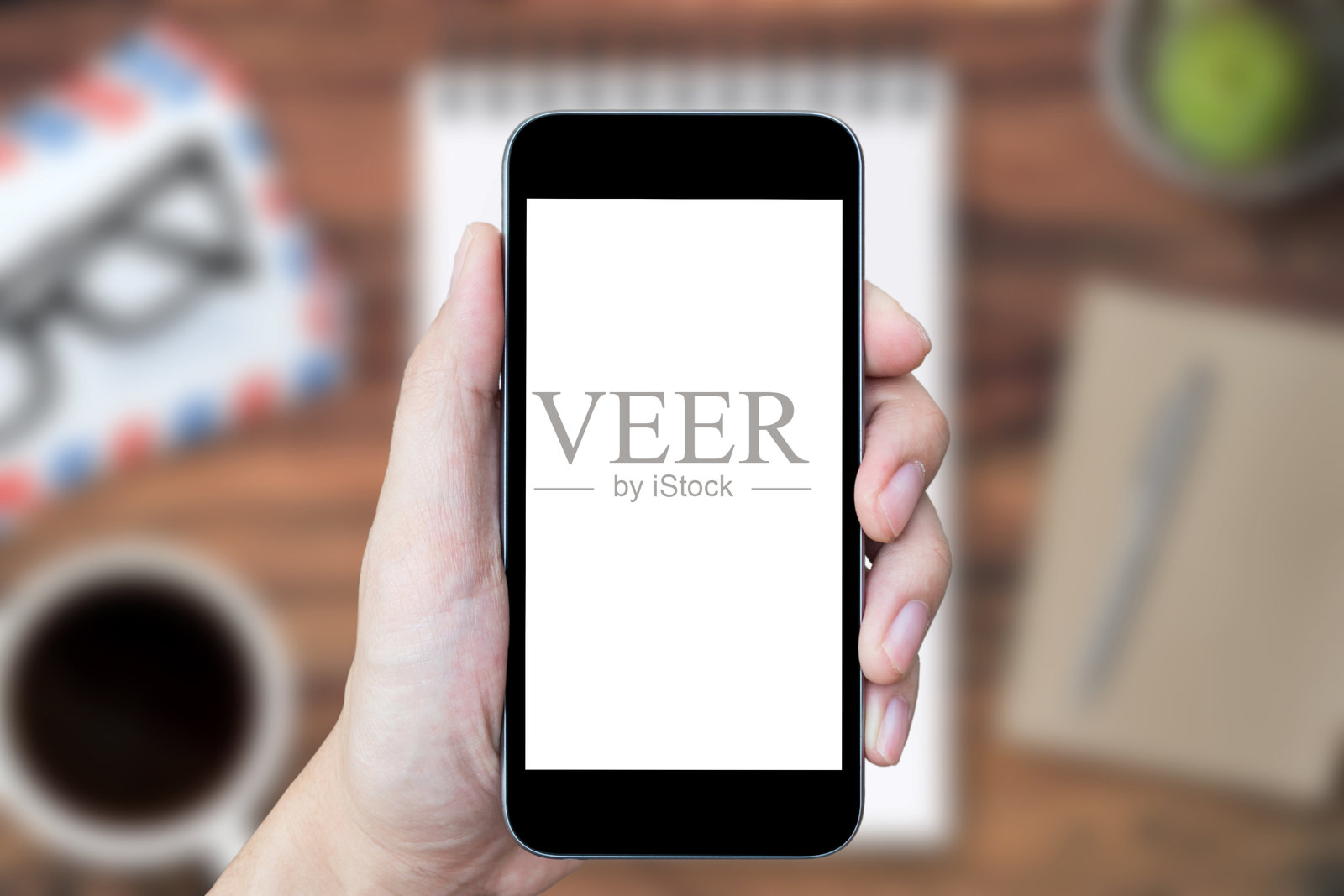 特写镜头：修剪过的手握着智能手机照片摄影图片