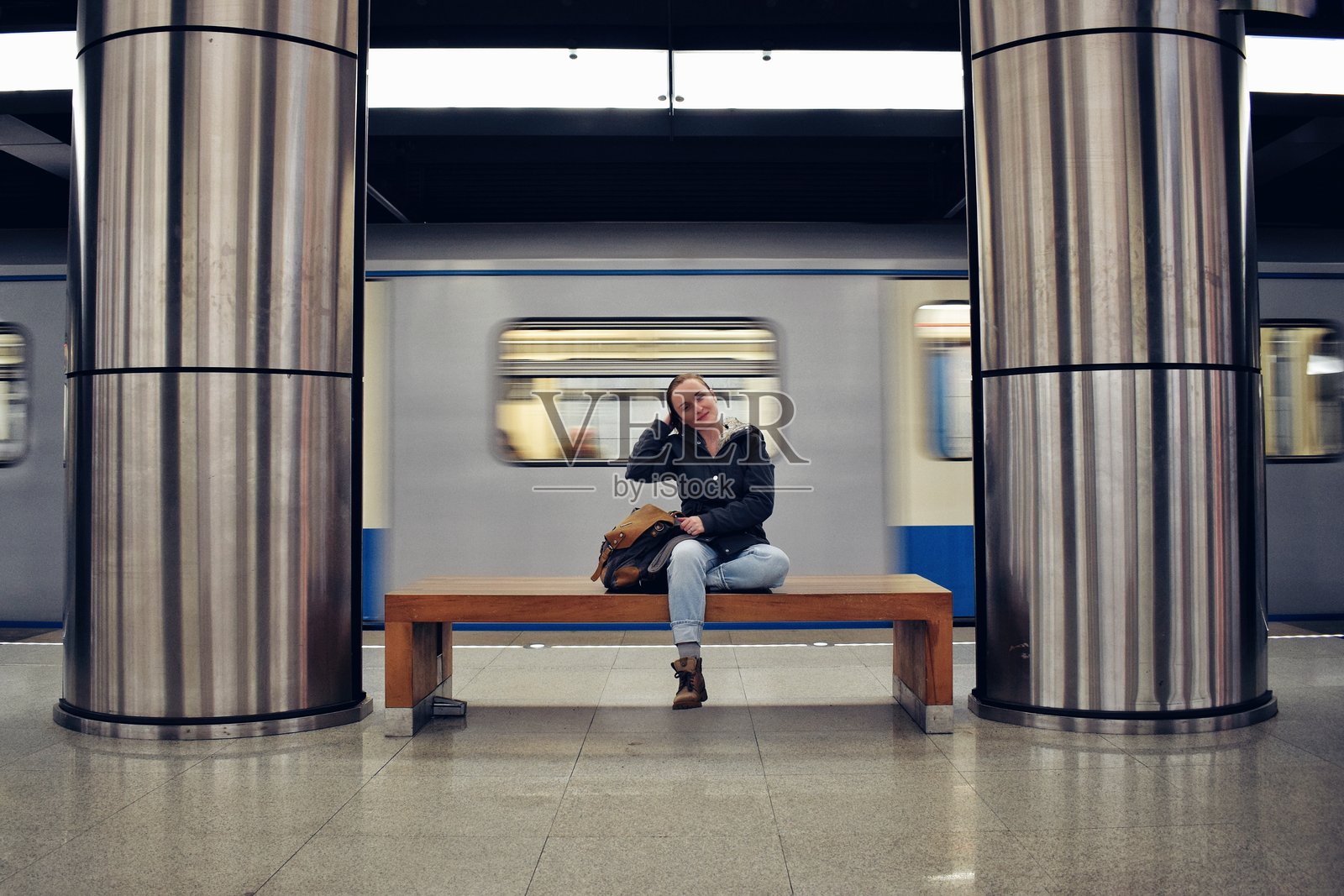 女性坐在地铁站台上的全身照照片摄影图片