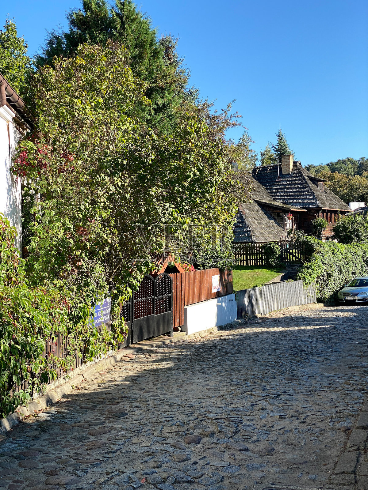 一条街道，右边有一栋房子，左边有一棵树照片摄影图片