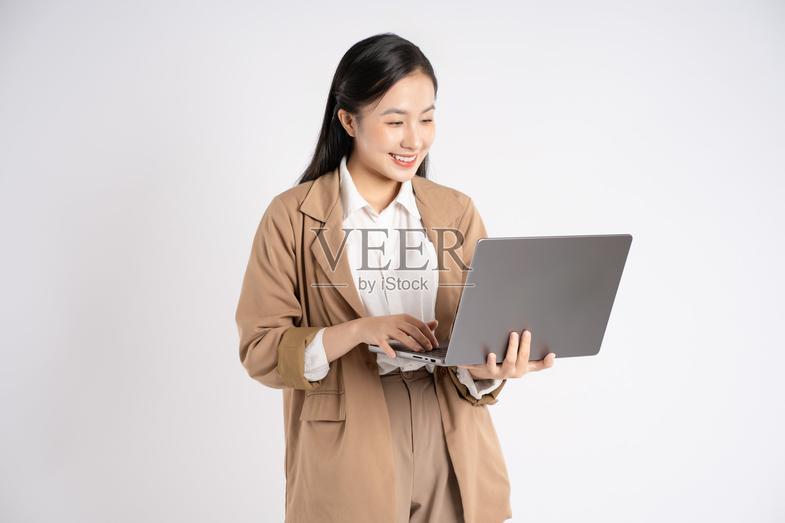年轻亚洲女商人在白色背景下使用笔记本电脑的肖像照片摄影图片